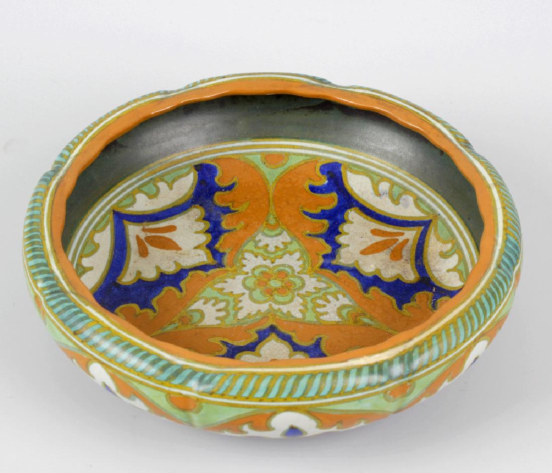 A Gouda pottery bowl. Of slightly lobed form decorated: A Gouda pottery bowl. Of slightly lobed form decorated in orange, blue and cream glaze, the whole raised upon three short feet, marks beneath, 10.75 (27 cm) diameter.