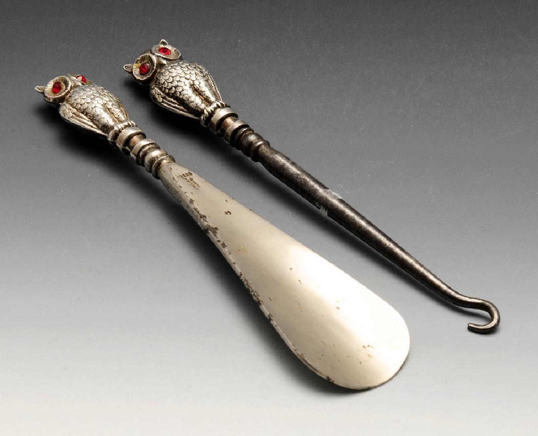 An Edwardian silver mounted shoe horn and button hook,: An Edwardian silver mounted shoe horn and button hook, each with silver terminals modelled as owls. Hallmarked Crisford & Norris Ltd, Birmingham 1906. Length of shoe horn measuring 6 inches (15.5 cm).
