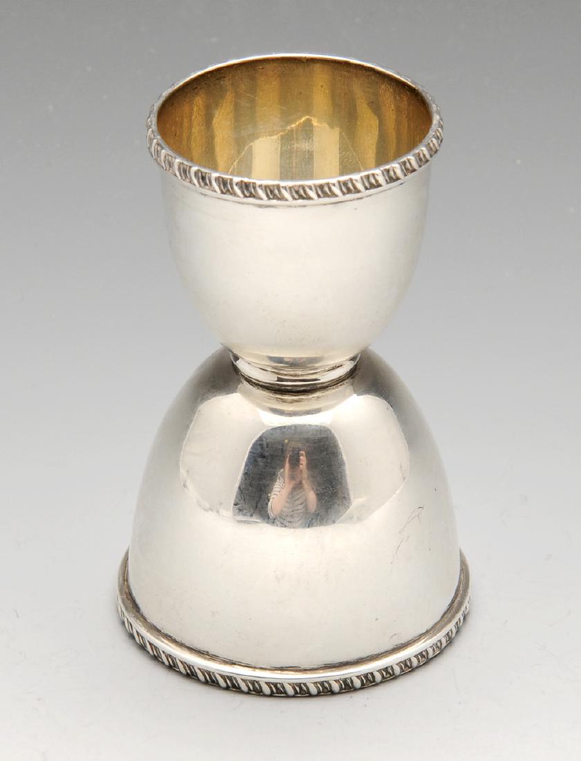 An Edwardian silver double-ended spirit measure with: An Edwardian silver double-ended spirit measure with gadrooned rim. Hallmarked James Wakely & Frank Clarke Wheeler, London 1906. Height measuring 3 3/8 inches (8.5 cm), weight 2.3 ozt (72 grams).