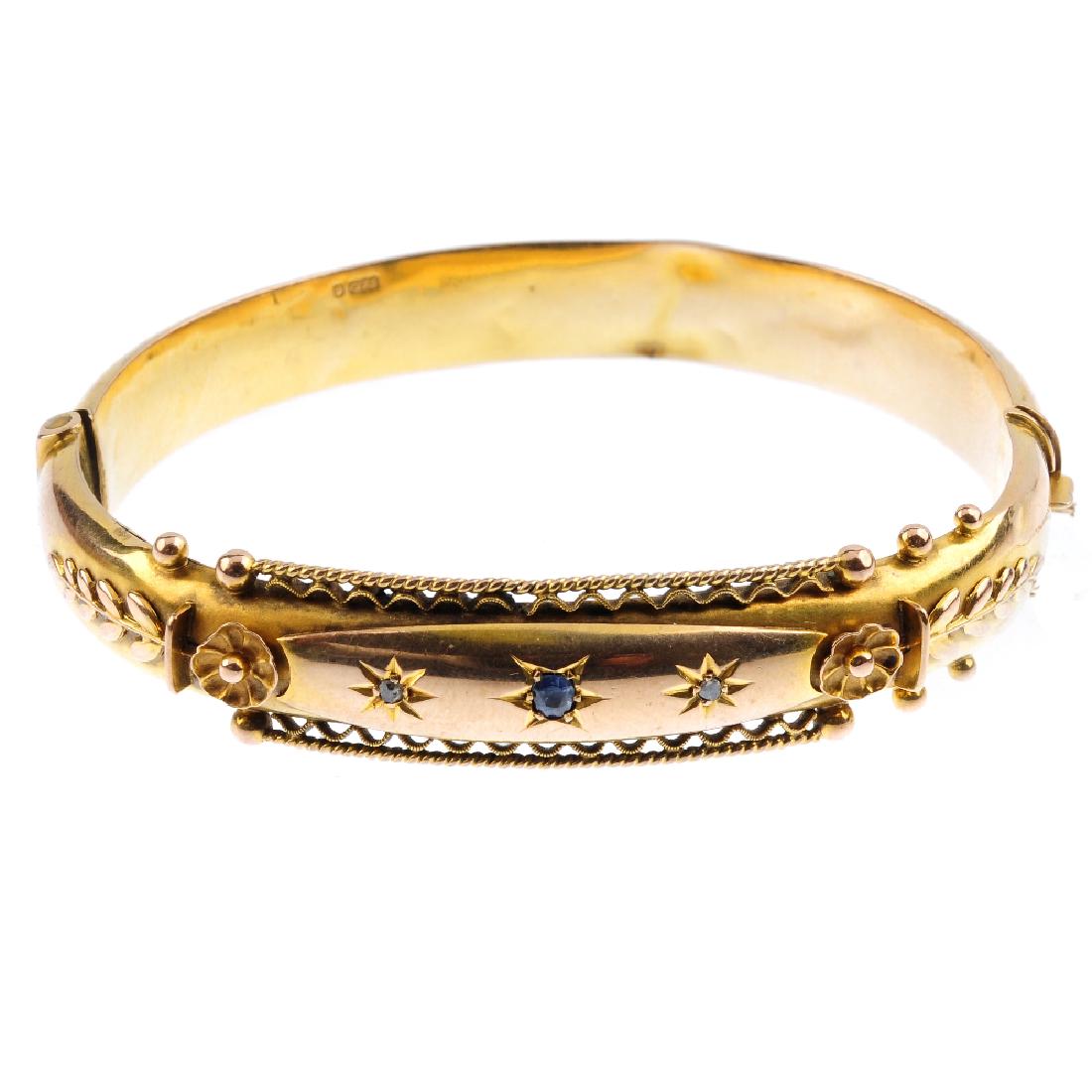 An early 20th century 9ct gold gem-set hinged bangle. (1 of 3)