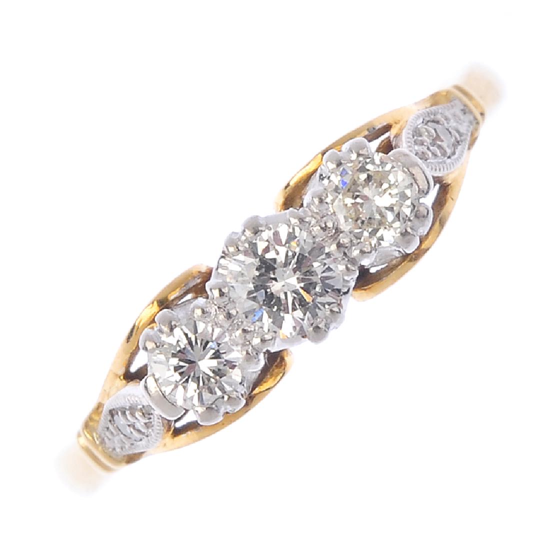 A diamond three-stone ring. Of bi-colour design, the (1 of 3)
