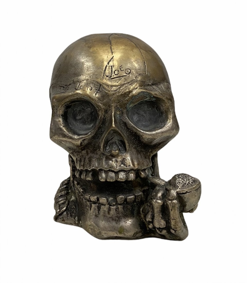 Artist Signed Metal Skull With Bandolier Smoking A Pipe: Signed Joe. Artist known 5 inches high. 6 x 4 in wide.