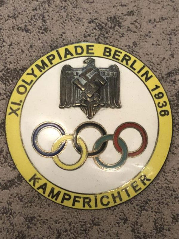 1936 BERLIN OLYMPICS KAMPFRICHTER (JUDGE) YELLOW PIN: VERY RARE 1936 BERLIN OLYMPICS KAMPFRICHTER (JUDGE) ENAMEL YELLOW PIN BADGE. IN MINT CONDITION WITH A BEAUTIFUL OVERALL PATINA. WOULD MAKE A GREAT ADDITION TO YOUR COLLECTION.