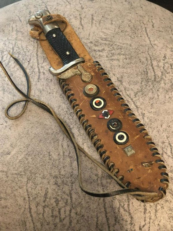 WW2 GERMAN SOLDIERS FIGHTING KNIFE WITH HANDMADE SHEATH: WW2 GERMAN SOLDIERS FIGHTING KNIFE WITH HANDMADE SHEATH. IN MINT OVERALL SHAPE AND CONDITION. THE SHEATH HAS VARIOUS INSIGNIAS EMBEDDED ON IT. WE ARE GUESSING IT'S PROBABLY THE SOLDIERS INSIGNIAS. PLE