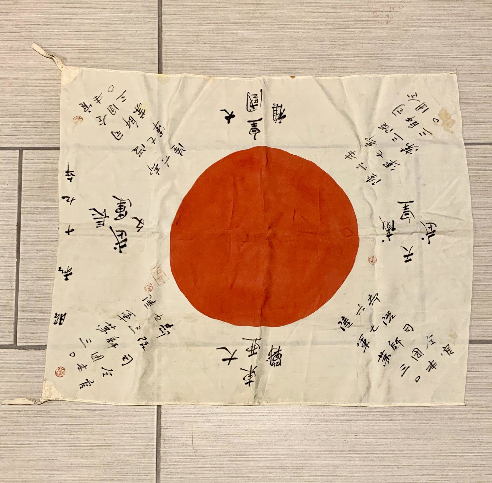 RARE WW2 SIGNED JAPANESE ARMY SILK FLAG: RARE WW2 SIGNED JAPANESE ARMY SILK FLAG. INK ON WHITE SILK WITH RED CENTRAL DISC. BEAUTIFUL MANUSCRIPT NOTATIONS IN JAPANESE EMANATING FROM THE CENTRAL DISC. THIS FLAG HAS STAMP MARKS AS WELL. PLEASE 