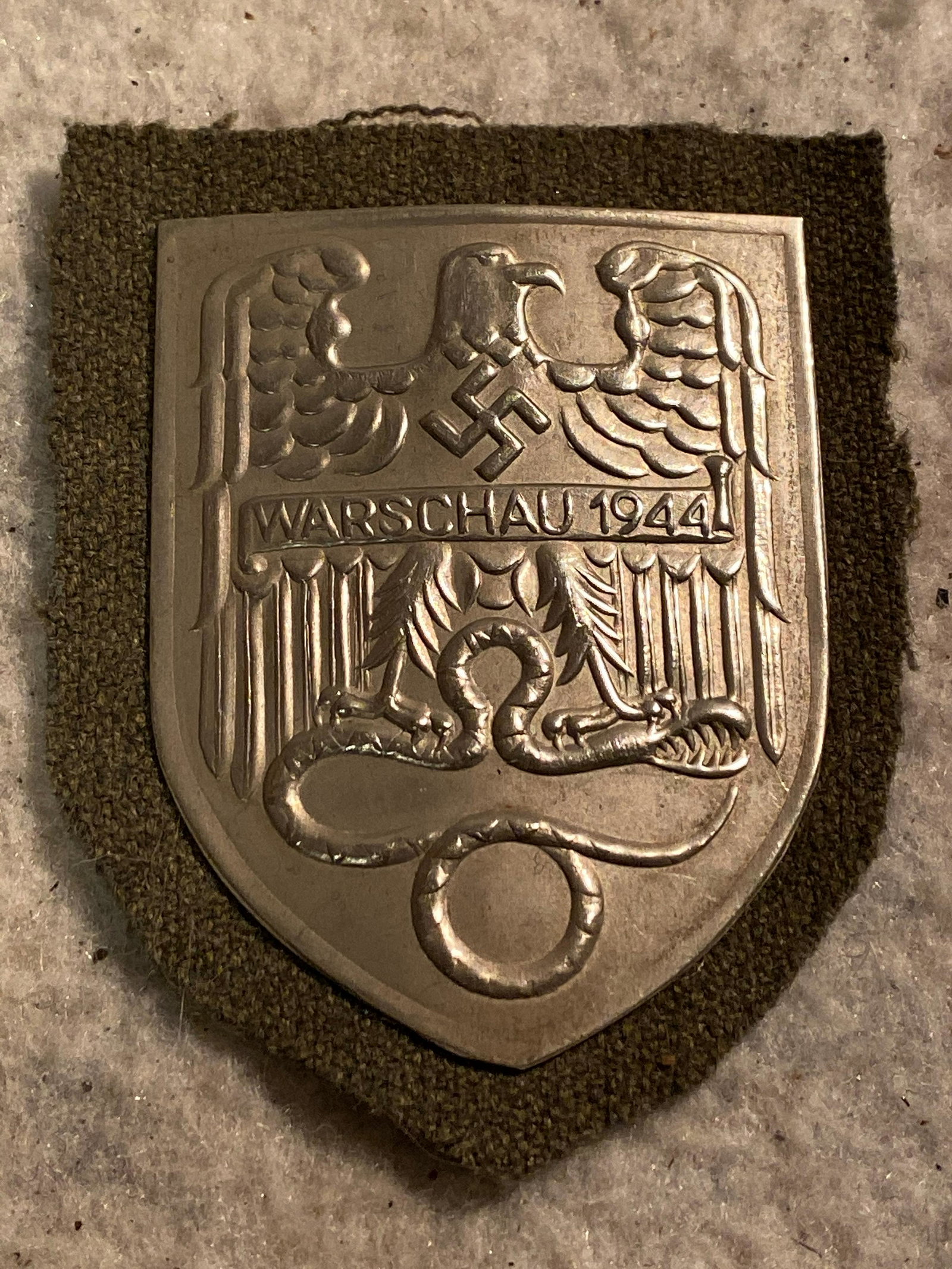 WW2 GERMAN NAZI WARSCHAU 1944 SHIELD: WW2 GERMAN NAZI WARSCHAU 1944 SHIELD. IN EXCELLENT SHAPE AND OVERALL CONDITION. HAS A BEAUTIFUL OVERALL PATINA. A GREAT FIND AND AN EXCELLENT ADDITION TO YOUR COLLECTION.