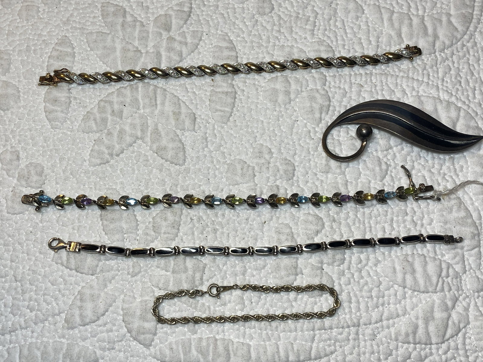 HIGH GRADE LOT OF LADIES STERLING SILVER JEWELRY: HIGH GRADE LOT OF LADIES STERLING SILVER JEWELRY. COMES WITH 3 SILVER TENNIS BRACELETS WITH GEMSTONES, 1 BROOCH, AND 1 SILVER BRACELET. A GREAT LOT FOR YOUR COLLECTION.