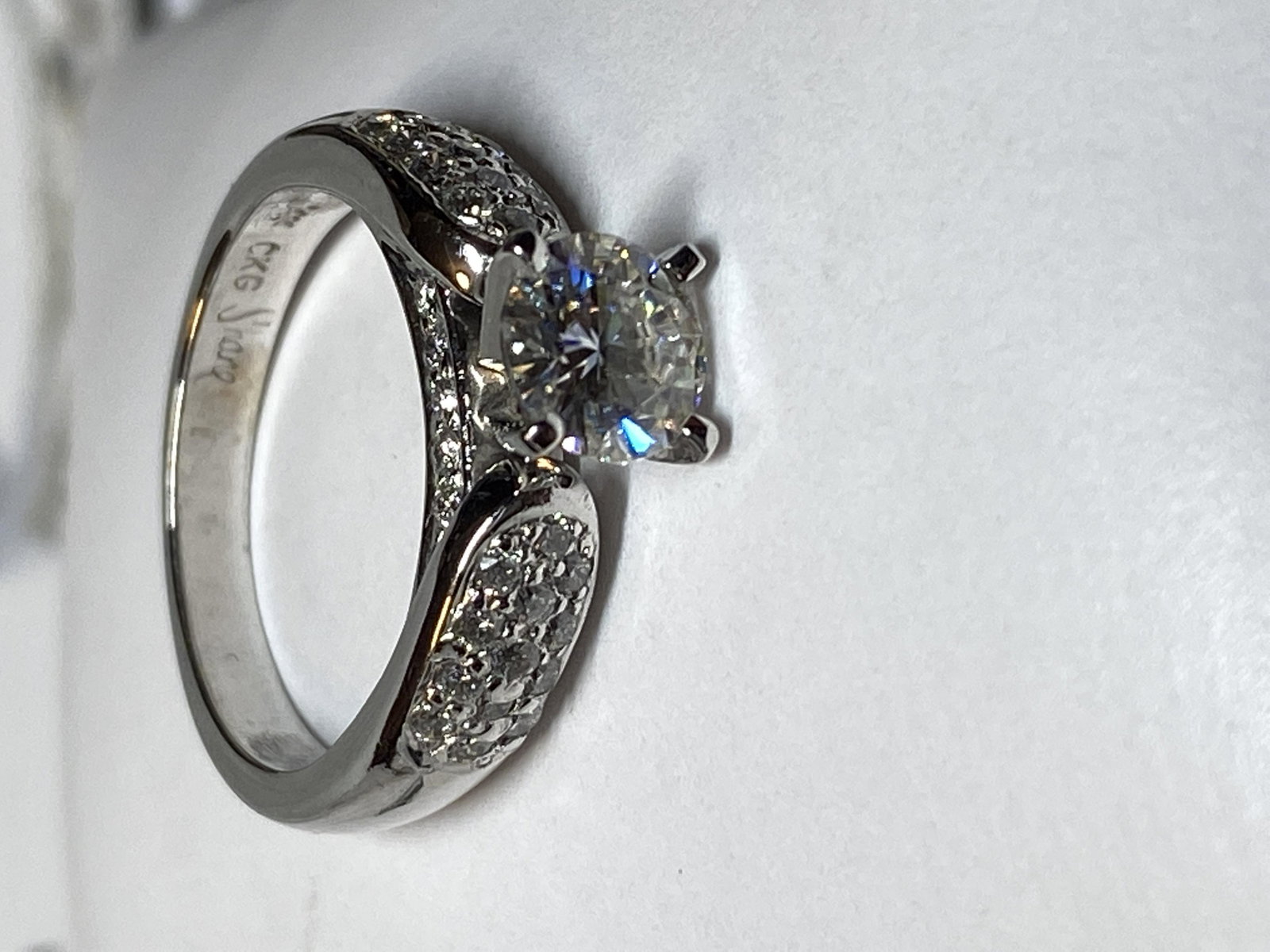 14K GOLD 1.10 TCW MOISSANITE ENGAGEMENT RING: 14K GOLD 1.10 TCW MOISSANITE ENGAGEMENT RING W/PAPERWORK. HAS A CENTER 0.86 CT ROUND MOISSANITE DIAMOND THAT IS VS2 IN CLARITY WITH A COLOR GRADING OF G-H, FLANKED WITH 0.34 TCW OF MATCHING DIAMONDS. 