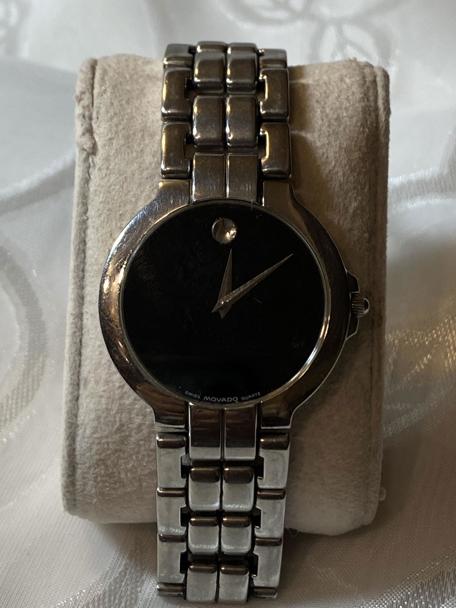 MOVADO MENS WATCH W/BLACK FACE: MOVADO MENS WATCH W/BLACK FACE. IN GOOD WORKING ORDER AND KEEPING TIME. BEAUTIFUL BLACK DIAL WITH A STEEL BRACELET THAT WILL ENHANCE YOUR WRIST PRESENCE. A GREAT FIND AND AN EXCELLENT ADDITION TO YOUR