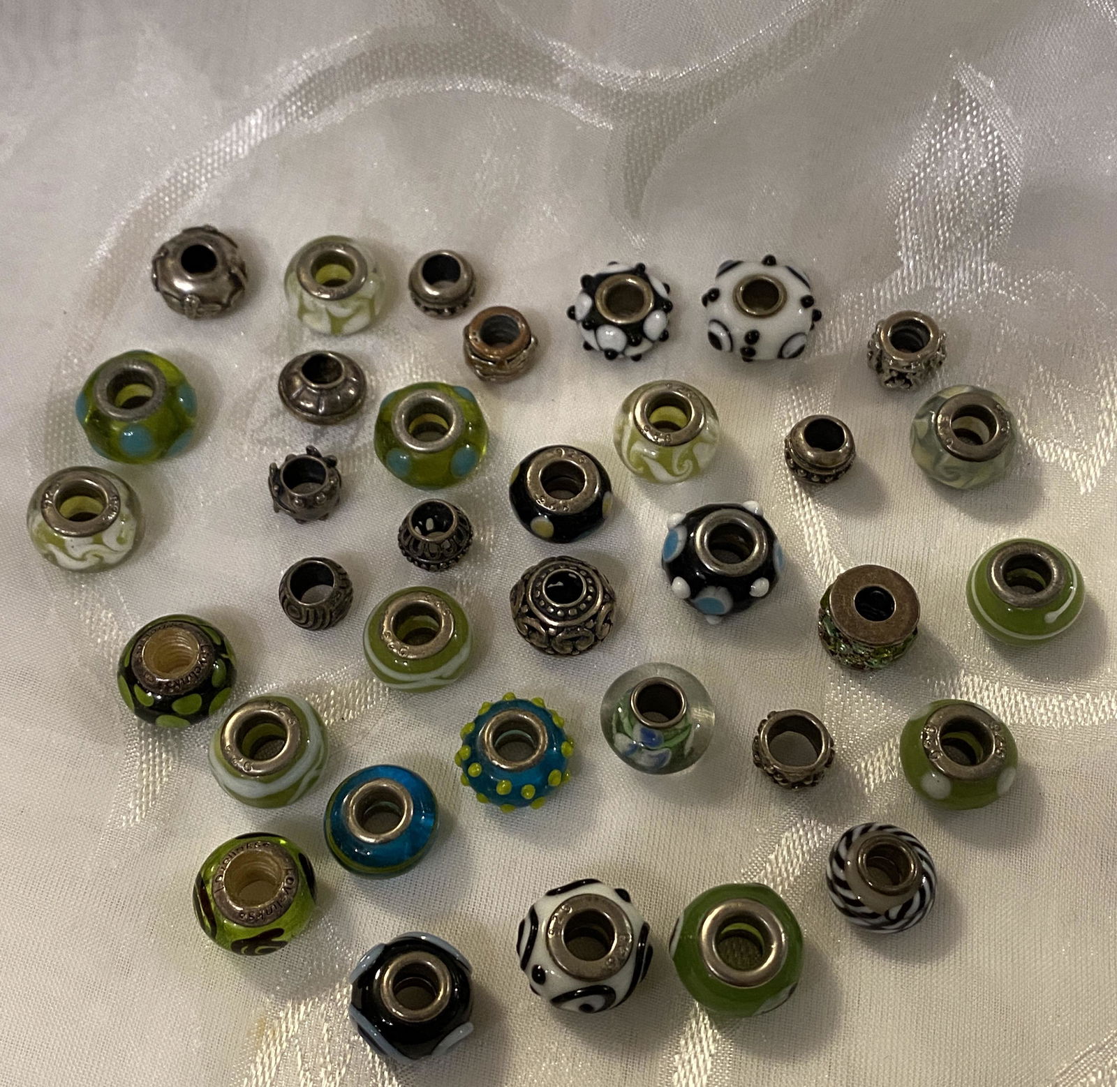 LOT OF (35) STERLING SILVER PANDORA STYLE BEADED CHARMS: LOT OF (35) STERLING SILVER PANDORA STYLE BEADED CHARMS. IN GOOD OVERALL SHAPE AND CONDITION. A GREAT FIND AND AN EXCELLENT ADDITION TO YOUR COLLECTION.