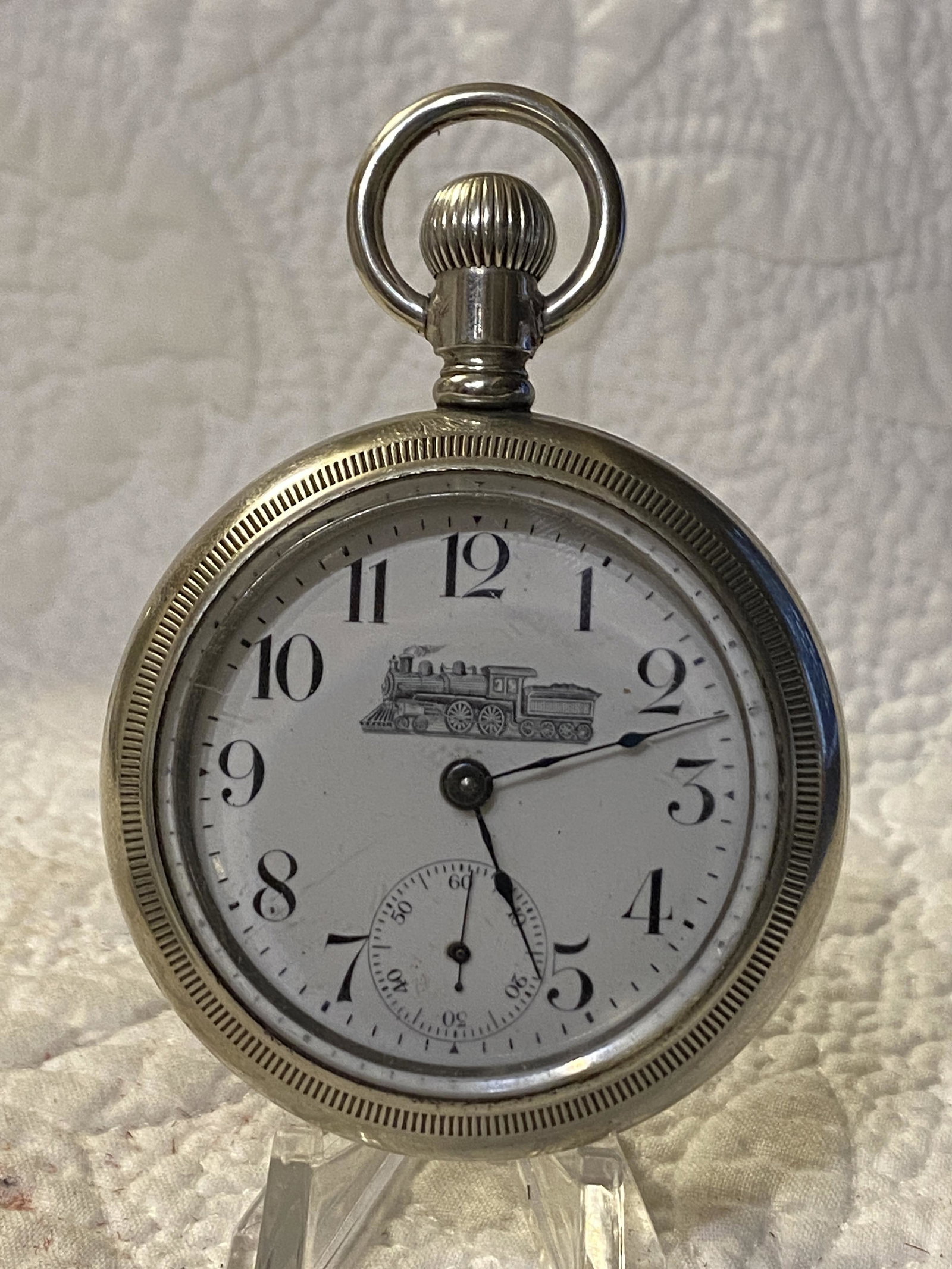 RARE NEW ERA TRAIN MOTIF RAILROAD POCKET WATCH: RARE NEW ERA TRAIN MOTIF RAILROAD POCKET WATCH. WATCH RUNS AND STOPS. HAS A BEAUTIFUL TRAIN MOTIF ON THE CASE AND THE PORCELAIN DIAL. THIS IS A LARGER SIZED MENS WATCH. A GREAT FIND AND AN EXCELLENT A