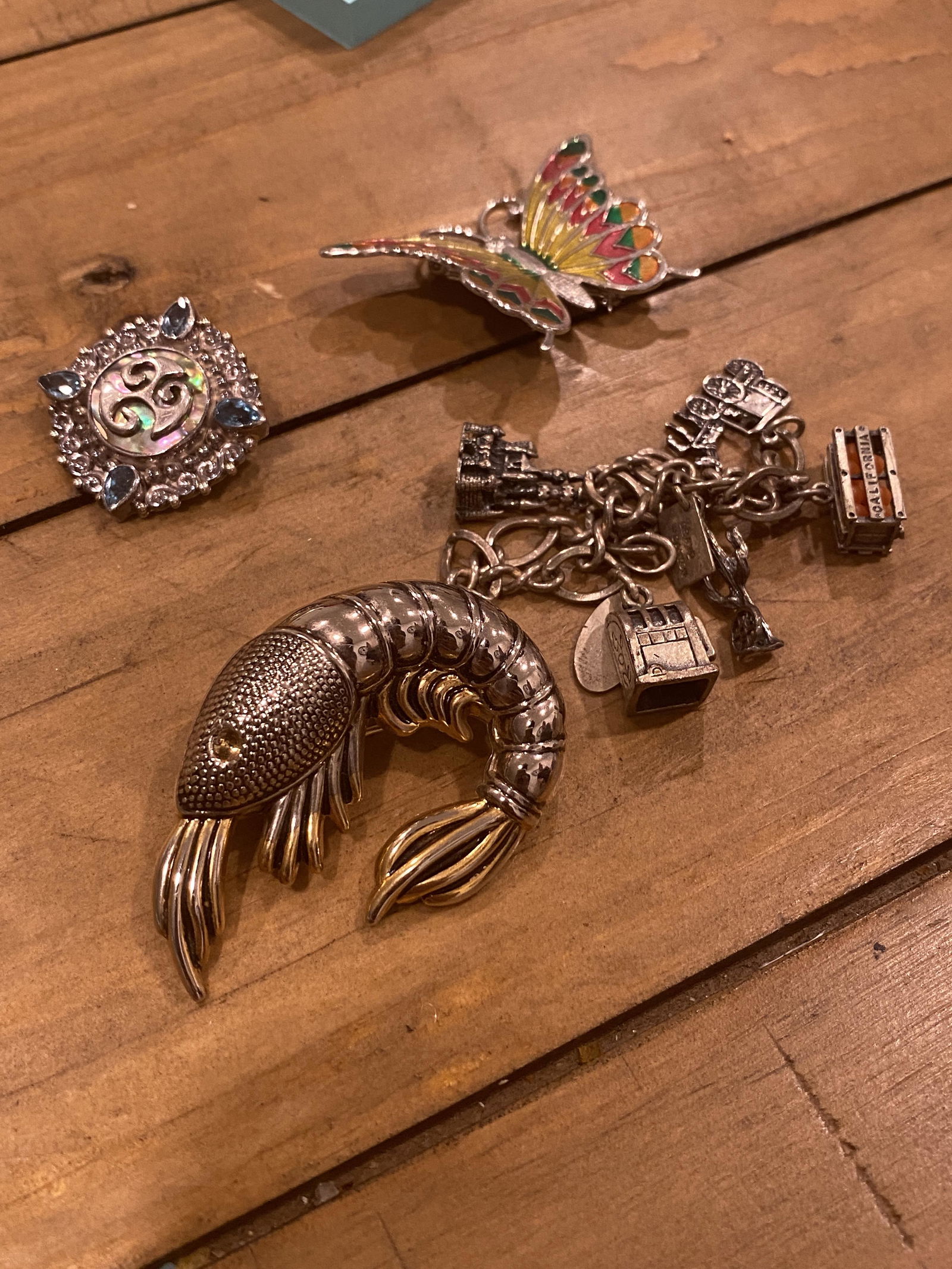 ESTAE LOT OF LADIES BROOCHES & CHARM BRACELET: ESTAE LOT OF LADIES BROOCHES & CHARM BRACELET. SOLD AS FOUND, AS A LOT.