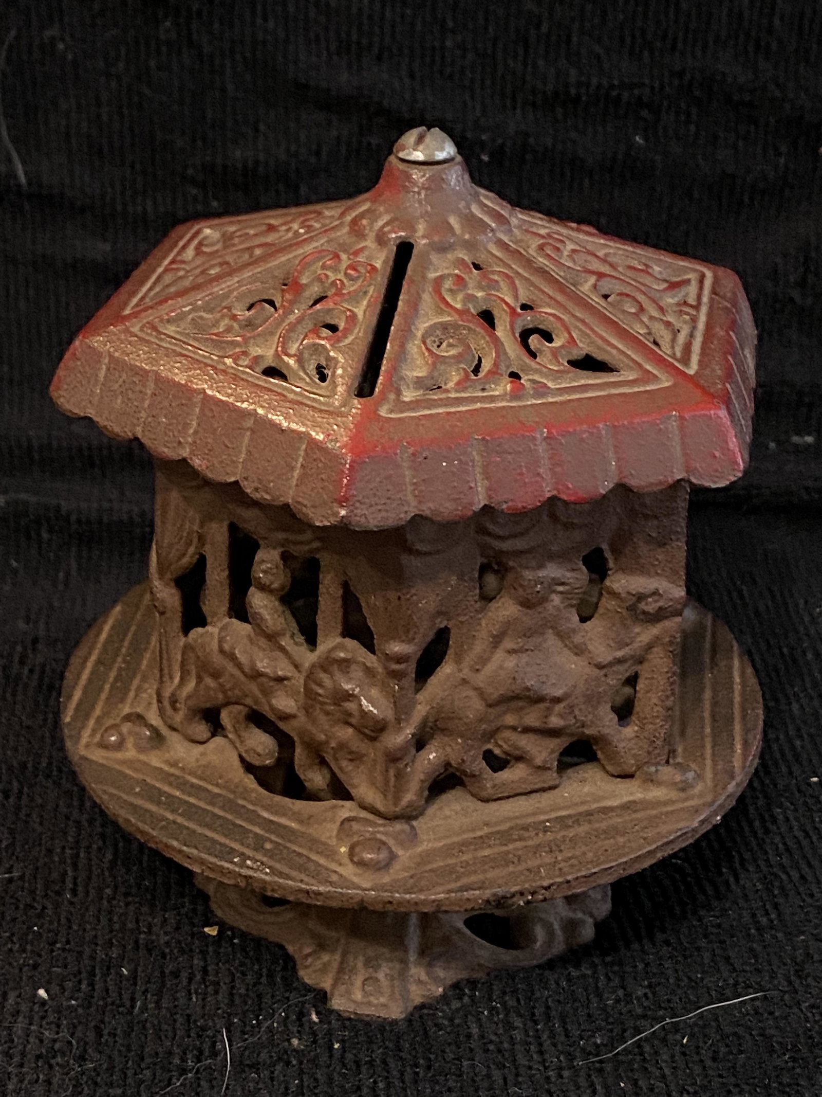 ANTIQUE CAST IRON MERRY GO ROUND COIN BANK: ANTIQUE CAST IRON MERRY GO ROUND COIN BANK. IN MINT OVERALL SHAPE AND CONDITION WITH A BEAUTIFUL OVERALL PATINA. A GREAT FIND AND AN EXCELLENT ADDITION TO YOUR COLLECTION.