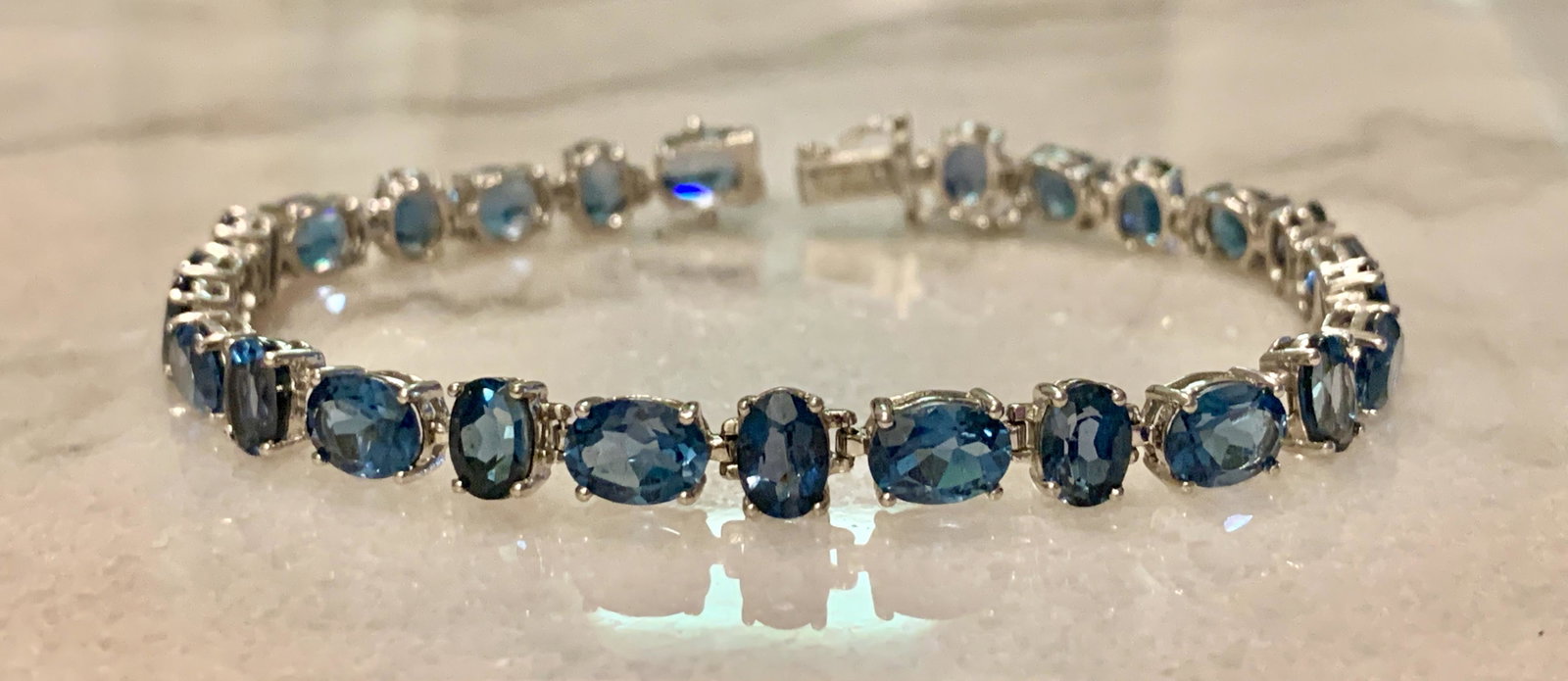 STERLING SILVER LADIES BLUE TOPAZ TENNIS BRACELET: STERLING SILVER LADIES BLUE TOPAZ TENNIS BRACELET. WILL FIT UP TO A 7 INCH WRIST. IN MINT OVERALL SHAPE AND CONDITION. A GREAT FIND AND AN EXCELLENT ADDITION TO YOUR COLLECTION.