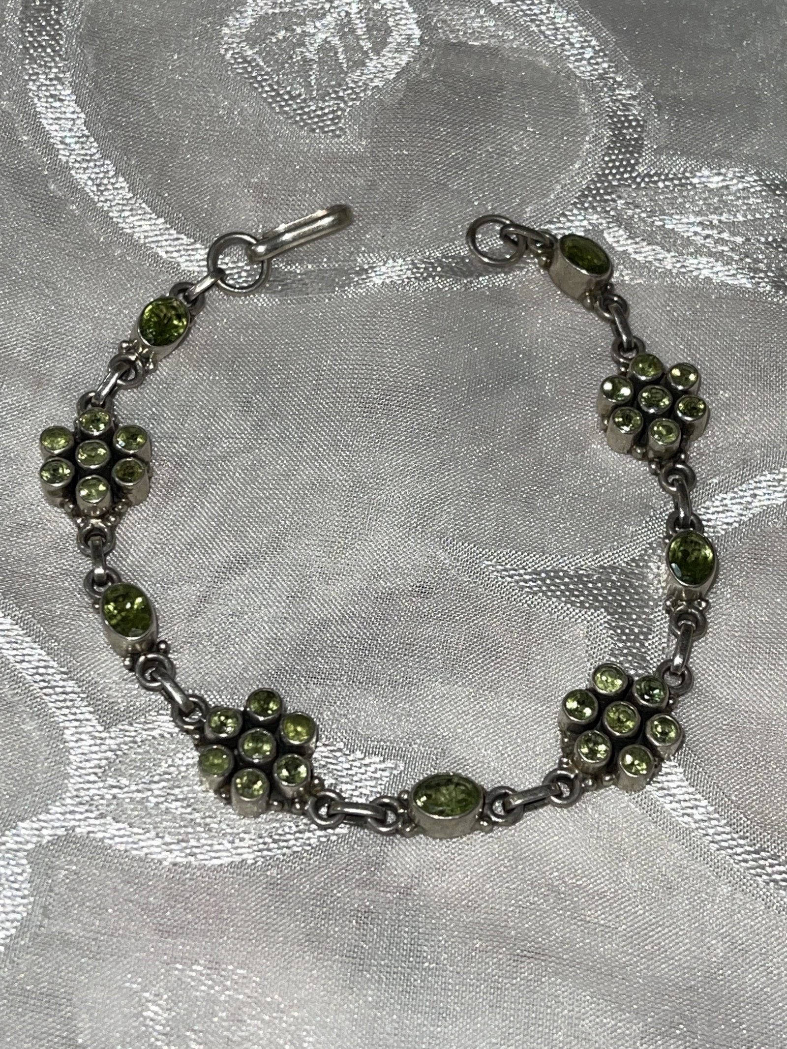 STERLING 4 TCW PERIDOT COCKTAIL BRACELET: STERLING 4 TCW PERIDOT COCKTAIL BRACELET. IN MINT OVERALL SHAPE AND CONDITION. A GREAT FIND AND AN EXCELLENT ADDITION TO YOUR COLLECTION.