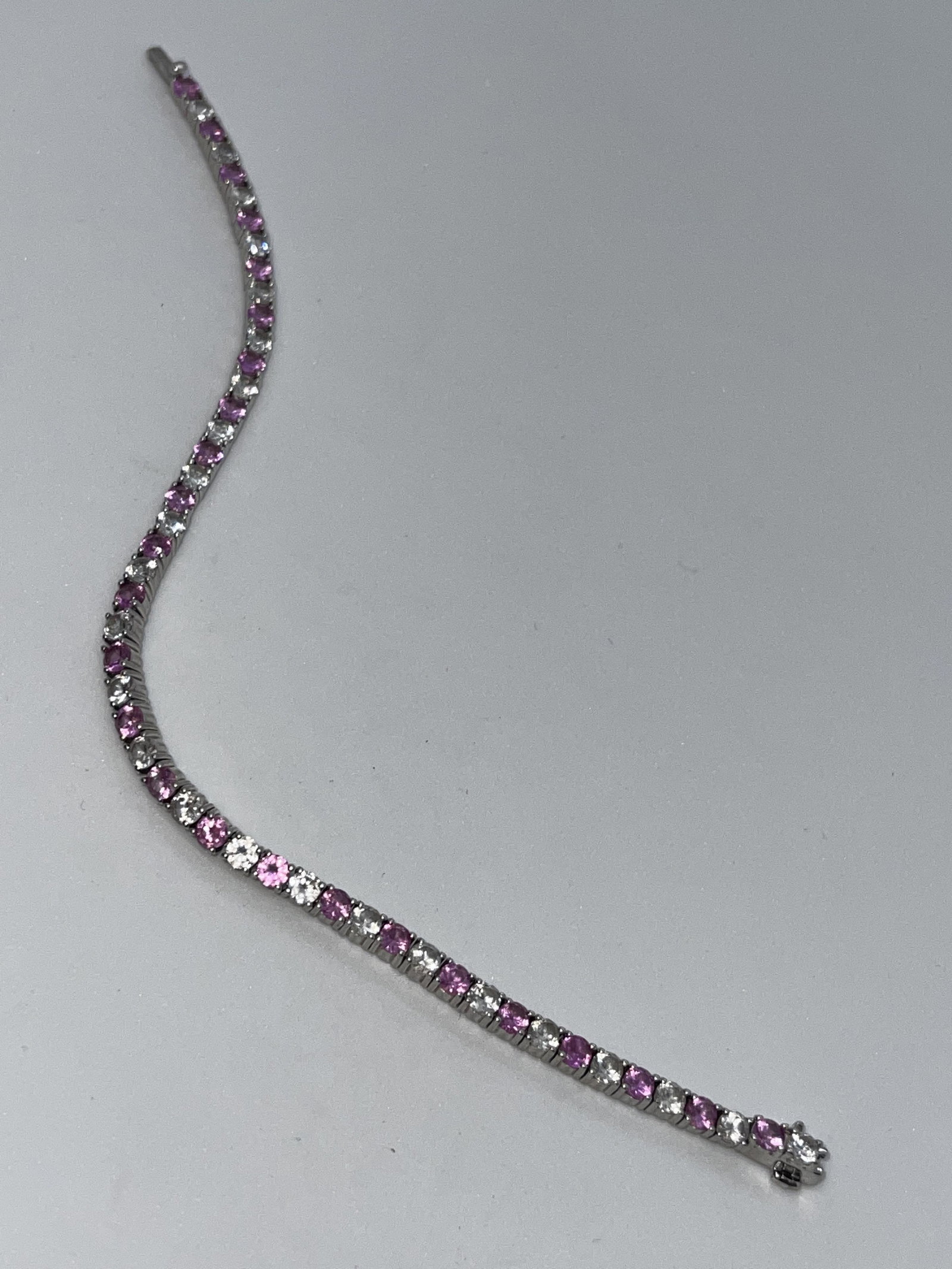 STERLING SILVER 7.5 TCW WHITE/PINK SAPPHIRES TENNIS: STERLING SILVER 7.5 TCW WHITE/PINK SAPPHIRES TENNIS BRACELET. IN MINT OVERALL SHAPE AND CONDITION. THESE GEMSTONES TEST AS NATURAL WHITE/PINK SAPPHIRES ON OUR GEM-TESTER. HAS A GREAT LOOK TO IT WITH A
