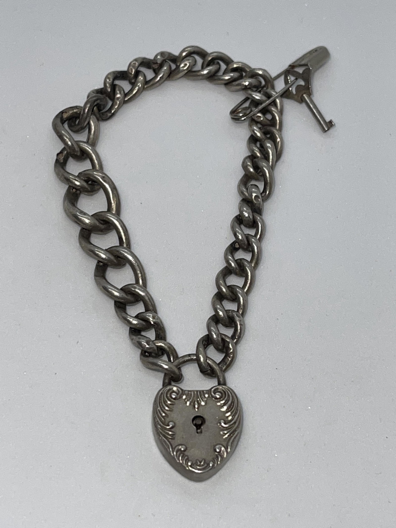 VICTORIAN STERLING SILVER HEART LOCK BRACELET WITH KEY: VICTORIAN STERLING SILVER HEART LOCK BRACELET WITH KEY. A RARE FIND. IN MINT OVERALL SHAPE AND CONDITION. HAS THE ORIGINAL KEY WITH IT. PLEASE VIEW ALL DETAILED PICTURES. A GREAT FIND.