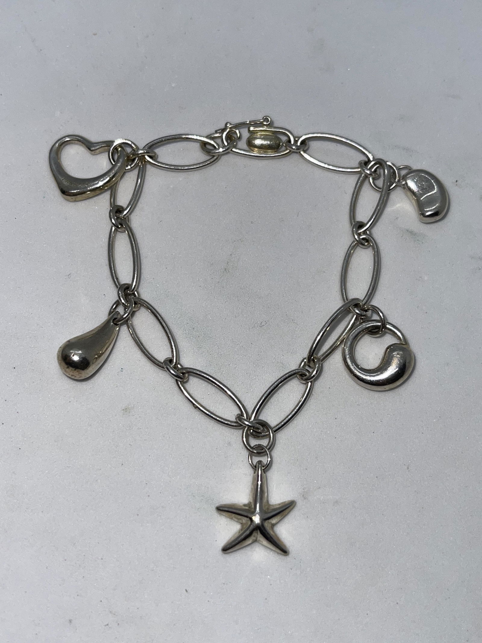 TIFFANY & CO. ELSA PERETTI CHARM BRACELET: TIFFANY & CO. ELSA PERETTI CHARM BRACELET. IN MINT OVERALL SHAPE AND CONDITION. HAS A GREAT LOOK TO IT WITH AN EXCELLENT OVERALL EYE APPEAL. PLEASE VIEW ALL DETAILED PICTURES. A GREAT FIND AND AN EXCE