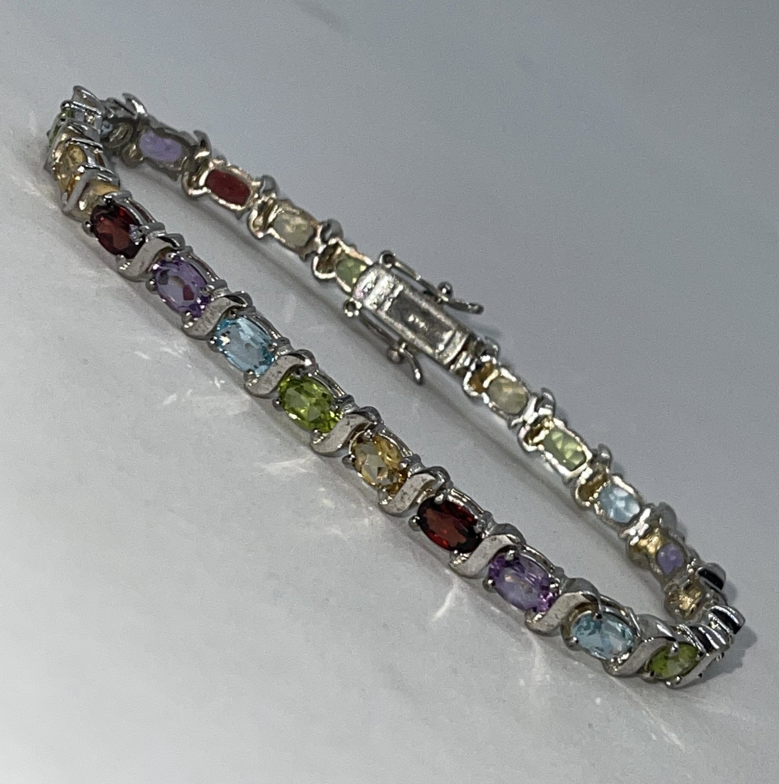 STERLING SILVER MULTI-STONE COCKTAIL TENNIS BRACELET: STERLING SILVER MULTI-STONE COCKTAIL TENNIS BRACELET. IN MINT OVERALL SHAPE AND CONDITION. HAS A GREAT LOOK TO IT WITH AN EXCELLENT OVERALL EYE APPEAL. A GREAT FIND AND AN EXCELLENT ADDITION TO YOUR C