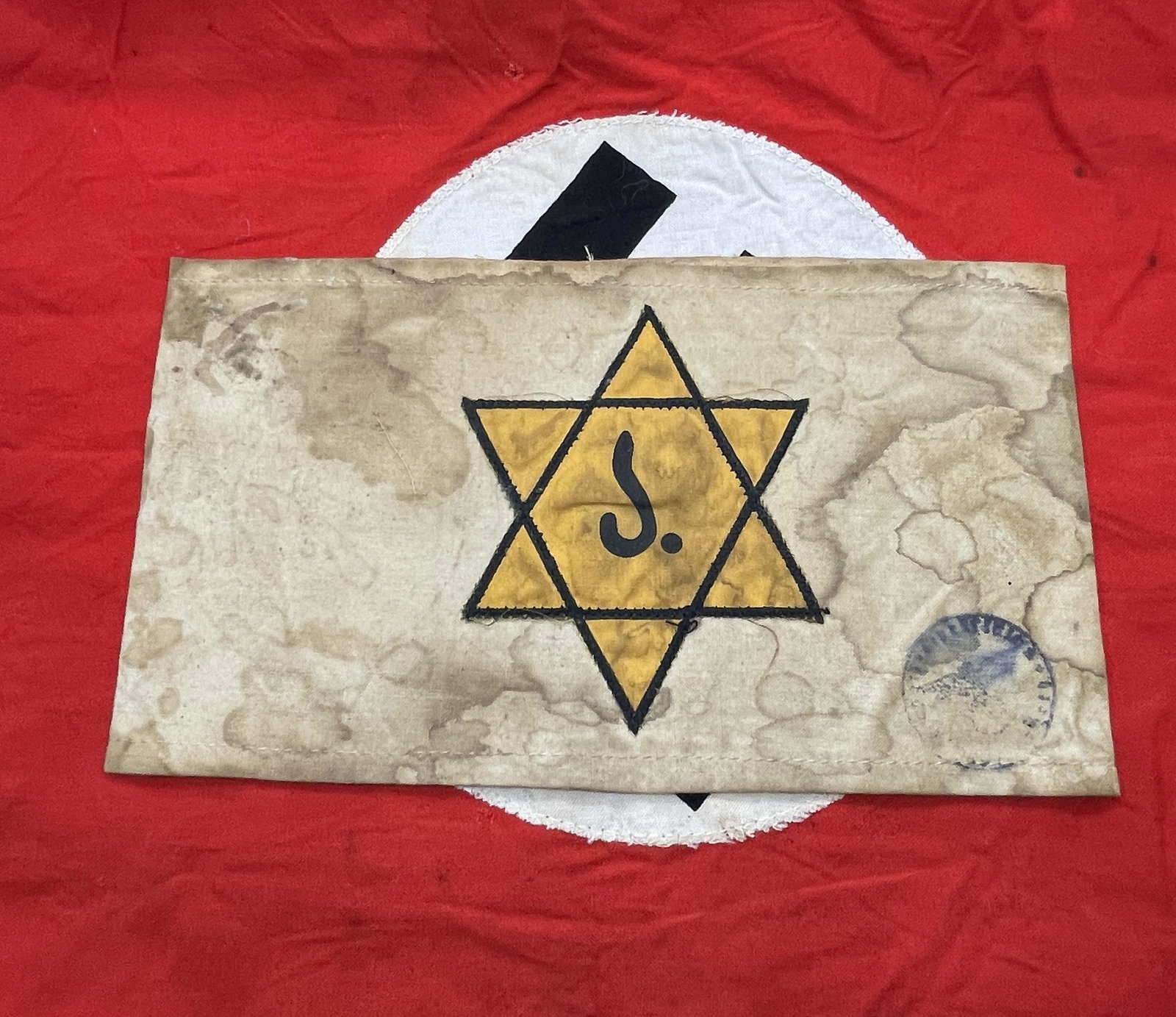 RARE WW2 GERMAN JUDE CONCENTRATION CAMP ARMBAND W/STAMP: RARE WW2 GERMAN JUDE CONCENTRATION CAMP ARMBAND W/STAMP. A VERY RARE FIND WITH THE STAR OF DAVID AND THE "J- JUDE" INSCRIBED IN THE MIDDLE OF IT. IN NAZI GERMANY, JEWS WERE PERSECUTED AND THEY HAD THE