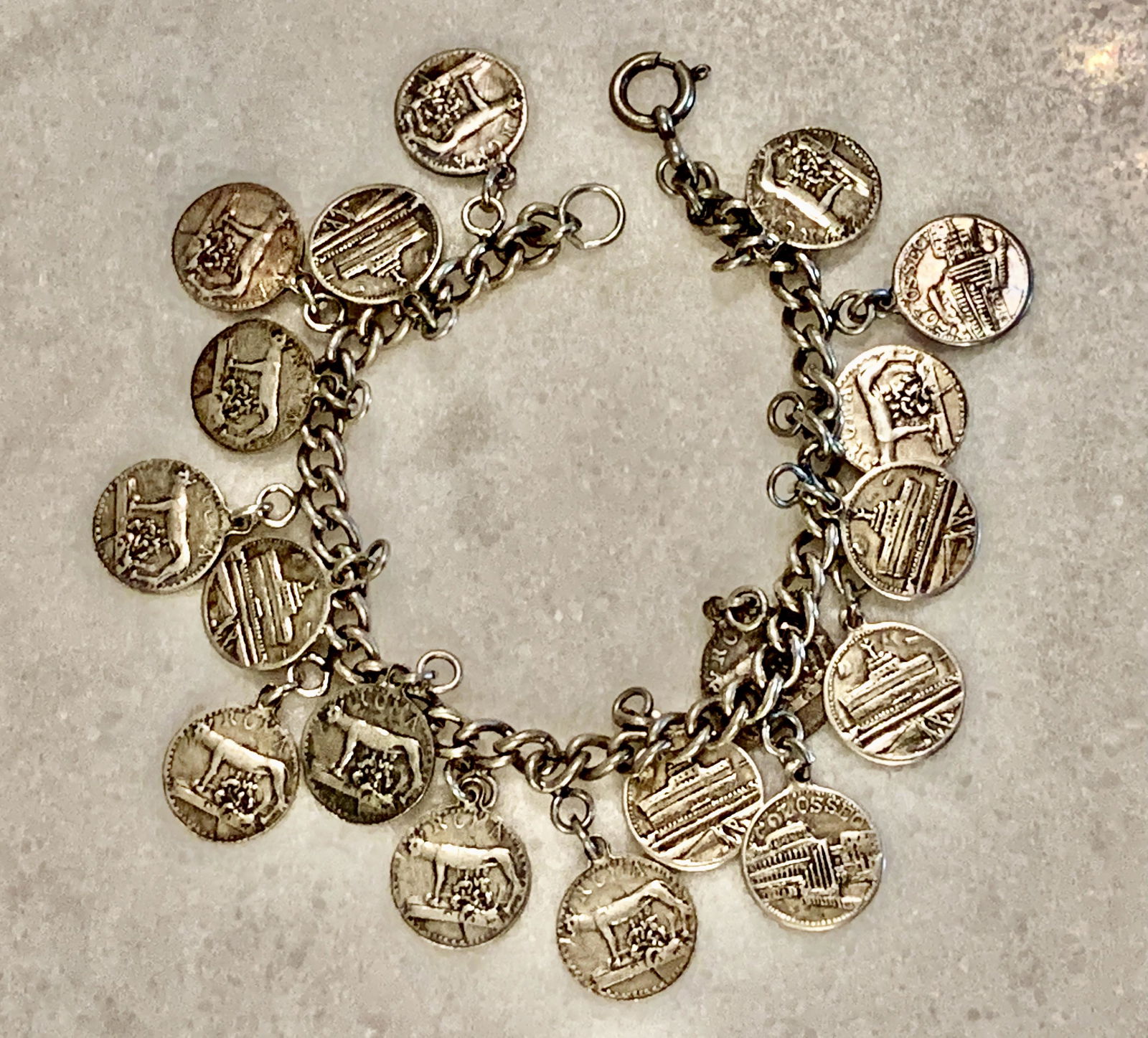 VINTAGE SILVER PLATE COINS MOTIF CHARMS BRACELET: VINTAGE SILVER PLATE COINS MOTIF CHARMS BRACELET. A GREAT FIND AND AN EXCELLENT ADDITION TO YOUR COLLECTION.