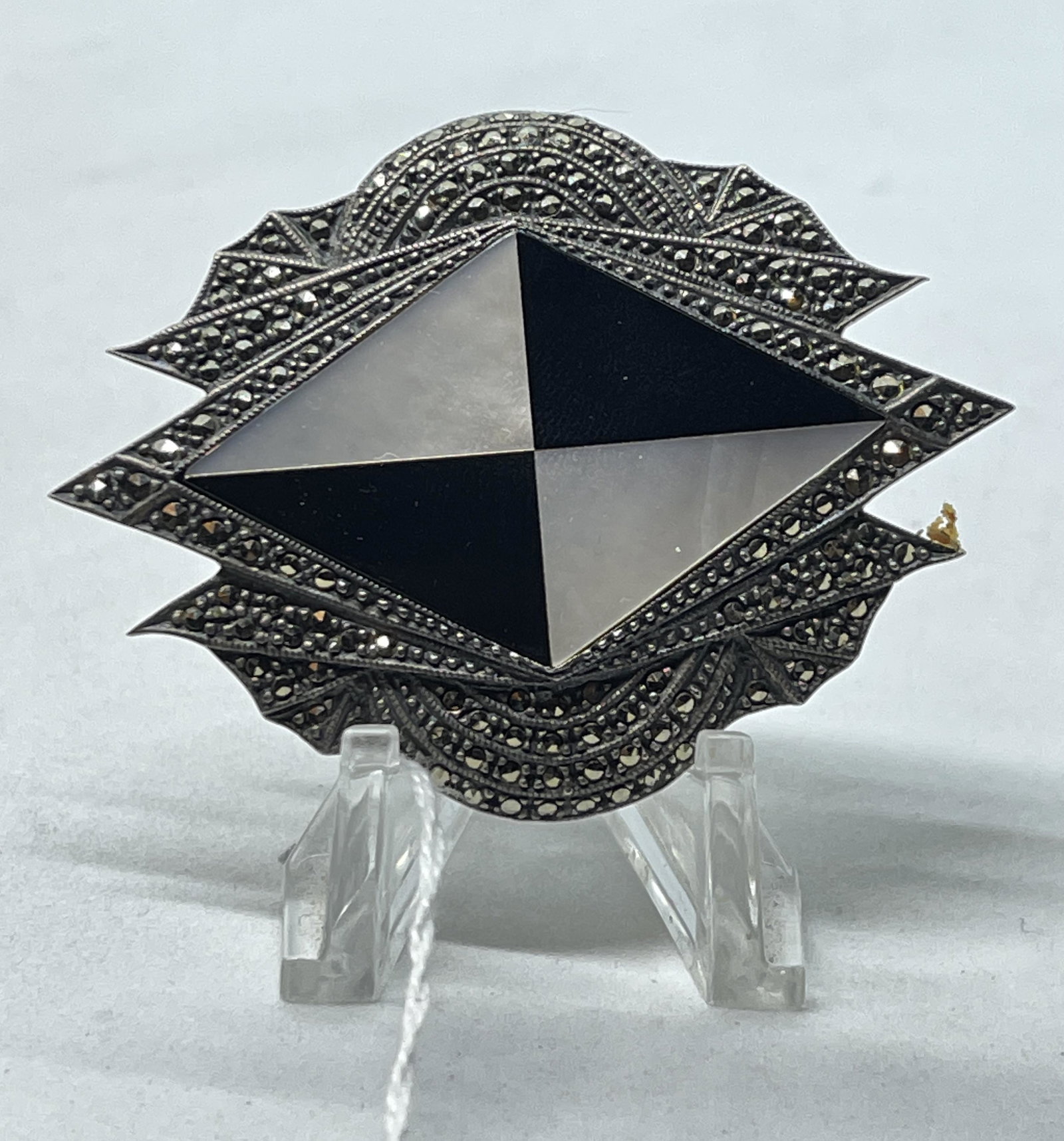 STERLING SILVER MARCASITE & MOP BROOCH: STERLING SILVER MARCASITE & MOP BROOCH. STERLING SILVER PIN, WITH MARCASITE SURROUNDING A MOTHER OF PEARL AND ONYX CENTER. MEASURES 2.5" X 2". A GREAT ADDITION TO YOUR COLLECTION.