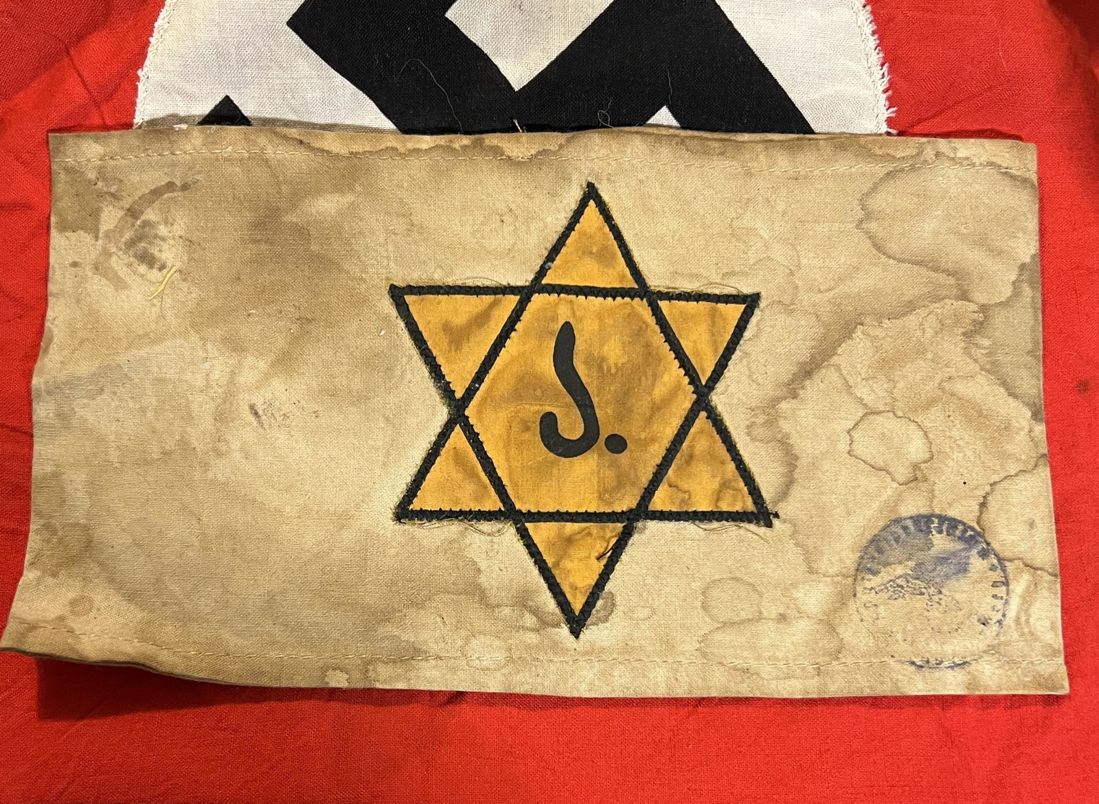 RARE WW2 GERMAN JUDE CONCENTRATION CAMP ARMBAND W/STAMP: RARE WW2 GERMAN JUDE CONCENTRATION CAMP ARMBAND W/STAMP. A VERY RARE FIND WITH THE STAR OF DAVID AND THE "J- JUDE" INSCRIBED IN THE MIDDLE OF IT. IN NAZI GERMANY, JEWS WERE PERSECUTED AND THEY HAD THE