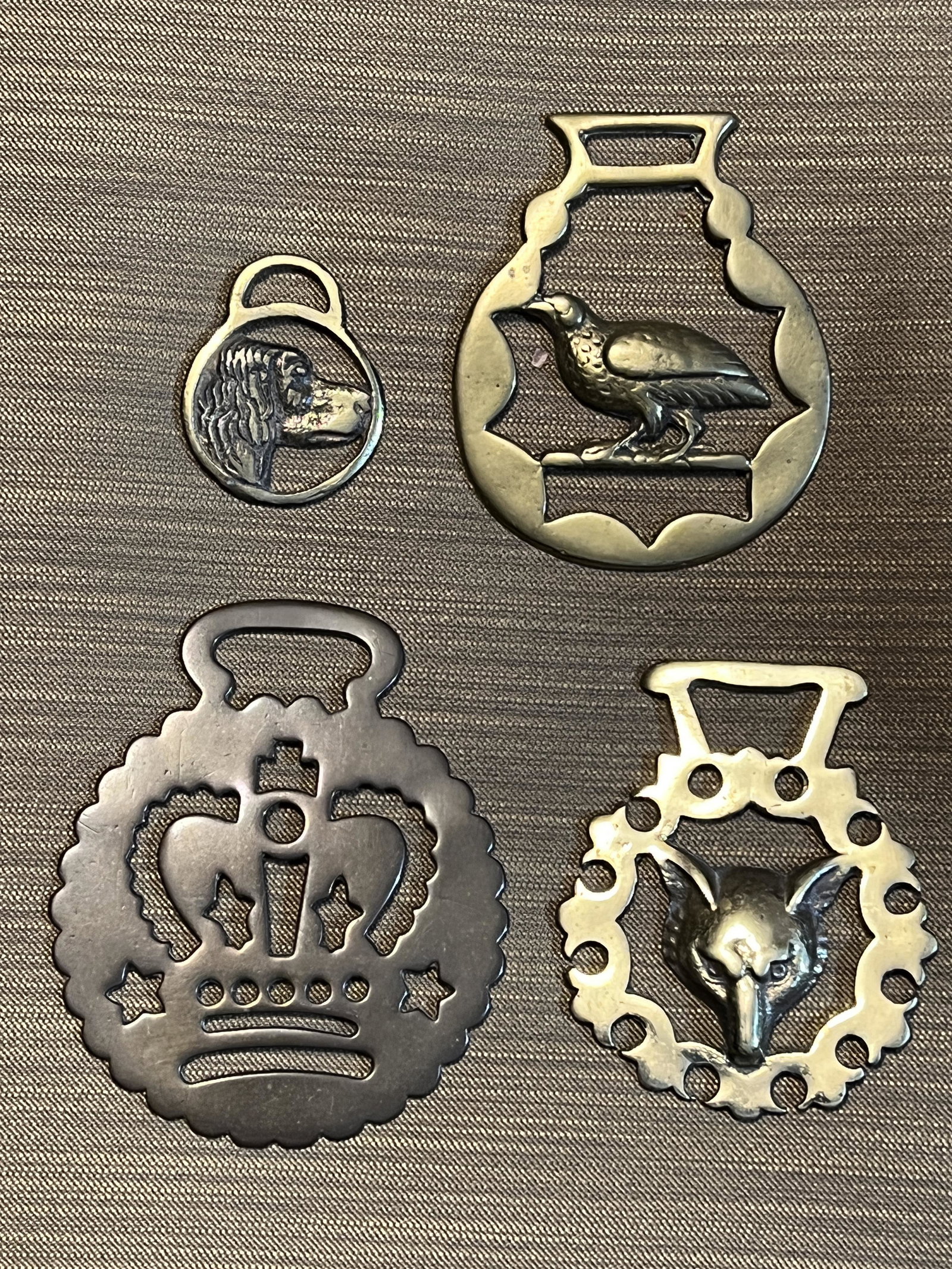 ANTIQUE 4 HORSE BRASSES: ANTIQUE 4 HORSE BRASSES. A DOG HEAD DESIGN MEASURING 1.75 X 1.5 INCHES, A CROWN DESIGN MEASURING 3.75 X 3.5, A FOXES HEAD MEASURING 3 X 3.5 INCHES AND A CROW MEASURING 3 X 3.5 INCHES. ALL HAVE OXIDATI