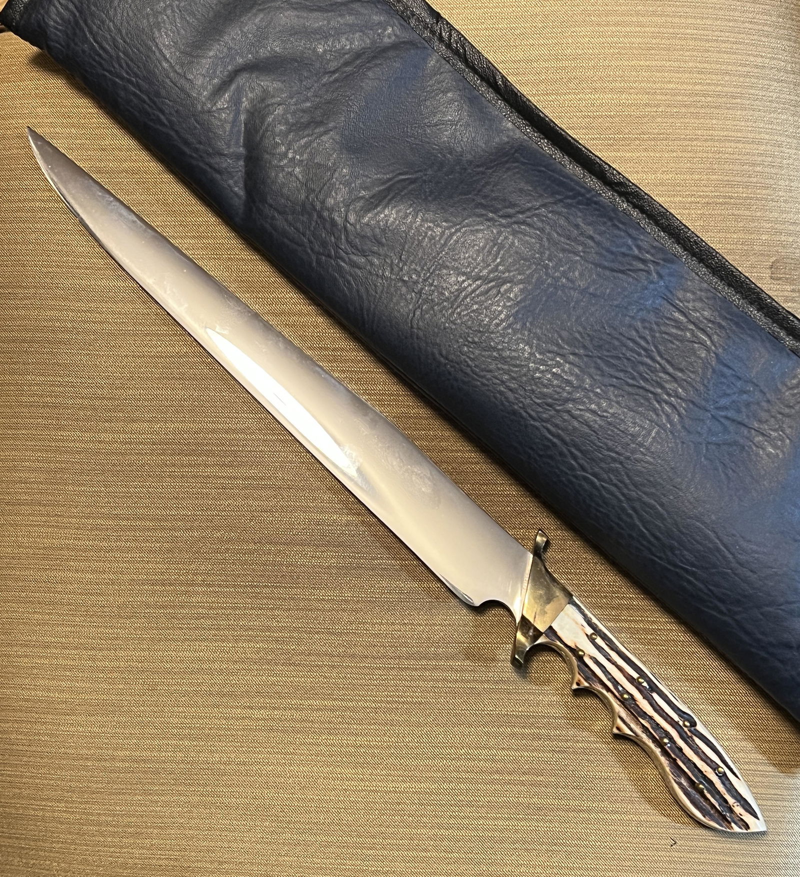 CUSTOM MADE 18IN FIXED BALDE KNIFE: CUSTOM MADE 18IN FIXED BALDE KNIFE. WHEN I LOOK AT IT I THINK SCAGEL OR A MODERN MARBLES KNIFE. BUT THERE IS NOT A SINGLE MARKING ON IT. TIP IS A NEEDLE. BLADE IS MIRROR LIKE. NO WIGGLES. 12 INCH BLAD