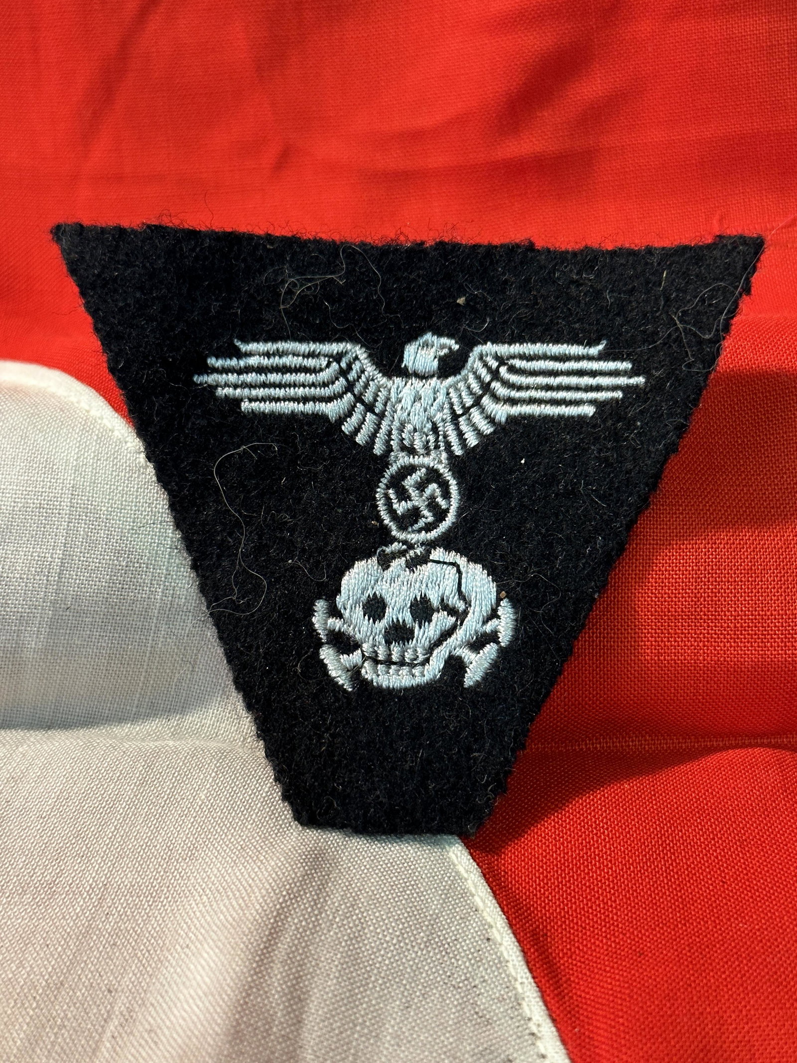 WW2 GERMAN TOTENKOPF SS SKULL AND EAGLE CLOTH BADGE: WW2 GERMAN TOTENKOPF SS SKULL AND EAGLE CLOTH BADGE. IT IS IN GOOD SHAPE AND CONDITION WITH A NICE PATINA THROUGHOUT. SHOWS WEAR AND TEAR. PLEASE VIEW ALL DETAILED PICTURES. A WELL MADE ANTIQUE GERMAN