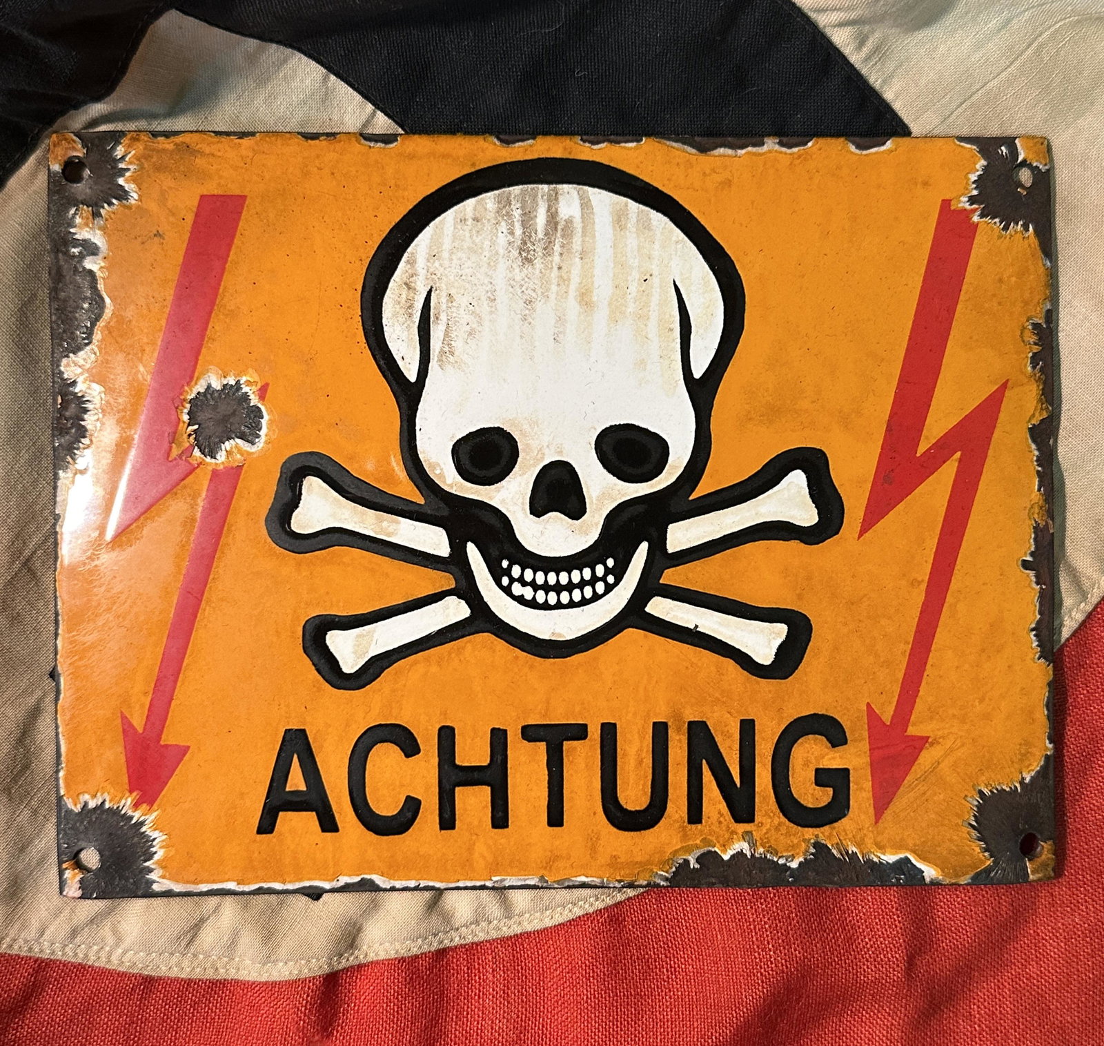 WW2 GERMAN ACHTUNG PORCELAIN SKULL AND BONES SIGN IN ORANGE: WW2 GERMAN ACHTUNG PORCELAIN SKULL AND BONES SIGN IN ORANGE. A RARE FIND. IT IS IN GOOD OVERALL SHAPE AND CONDITION WITH A BEAUTIFUL OVERALL PATINA. SHOWS GOOD WEAR AND USE. PLEASE VIEW ALL DETAILED P
