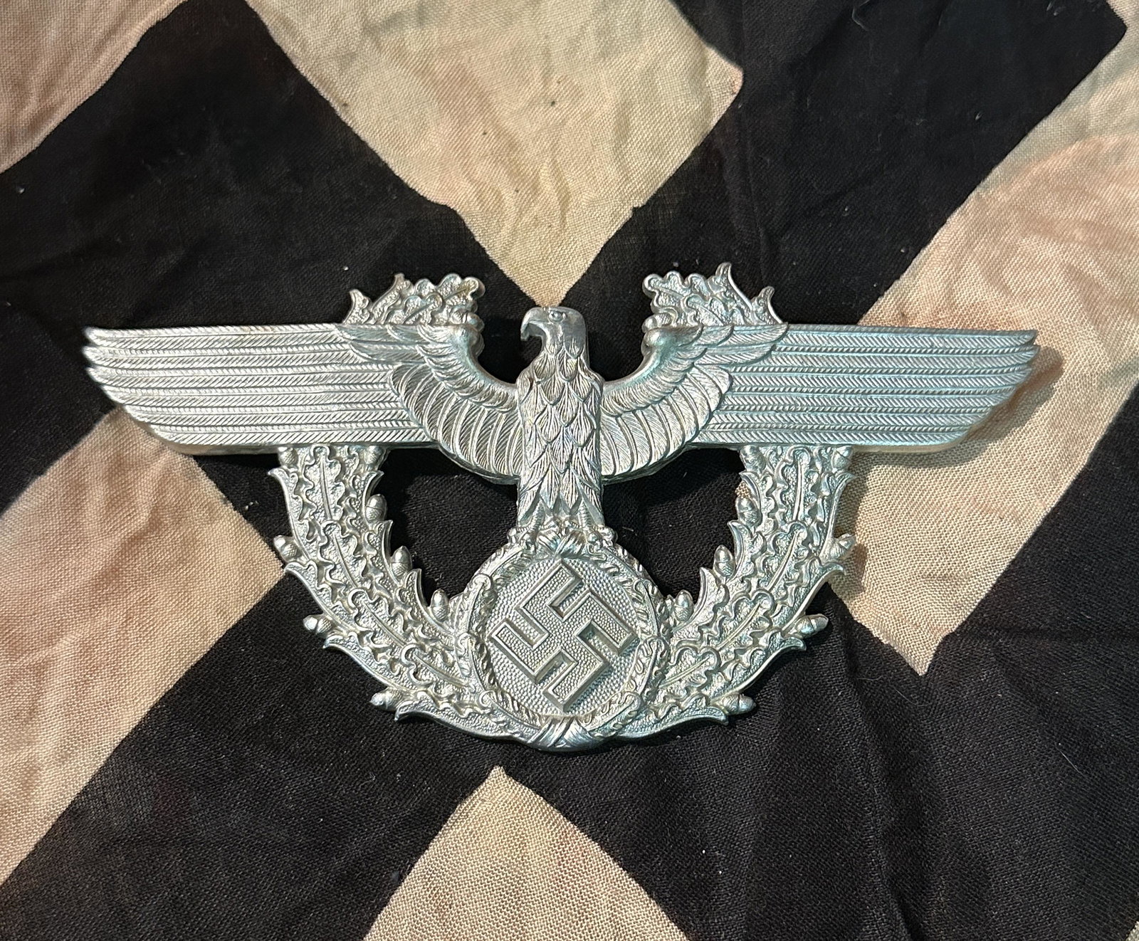 WW2 GERMAN POLICE UNIFROM KEPI LARGE CAP BADGE: WW2 GERMAN POLICE UNIFROM KEPI LARGE CAP BADGE. Die stamped aluminium eagle and wreath, retaining all original frosting and twin screw in posts to rear. Measures 158mm wide, not been shaped to fit kep