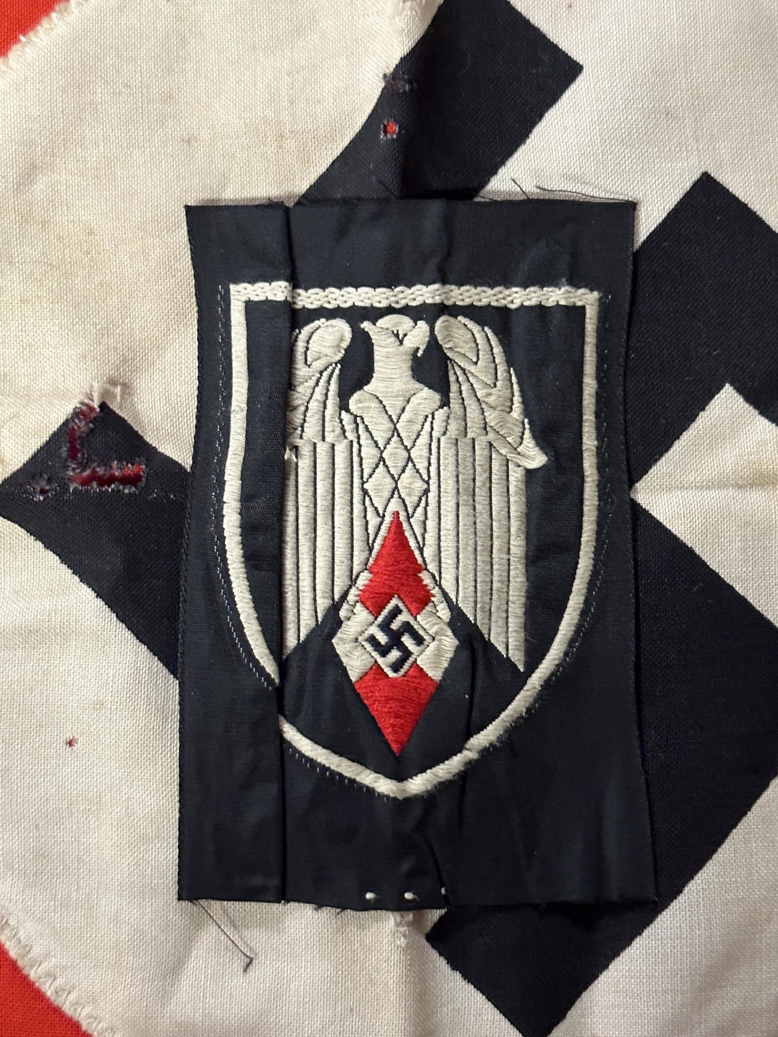 WW2 German Hitler Youth (Hitlerjugend) Flag Bearers Insignia: WW2 German Hitler Youth (Hitlerjugend) Flag Bearers Insignia. Cloth machine Bevo embroidered example. This badge showing an white eagle upon the HJ (Hitler Youth diamond on a black shield shaped backg