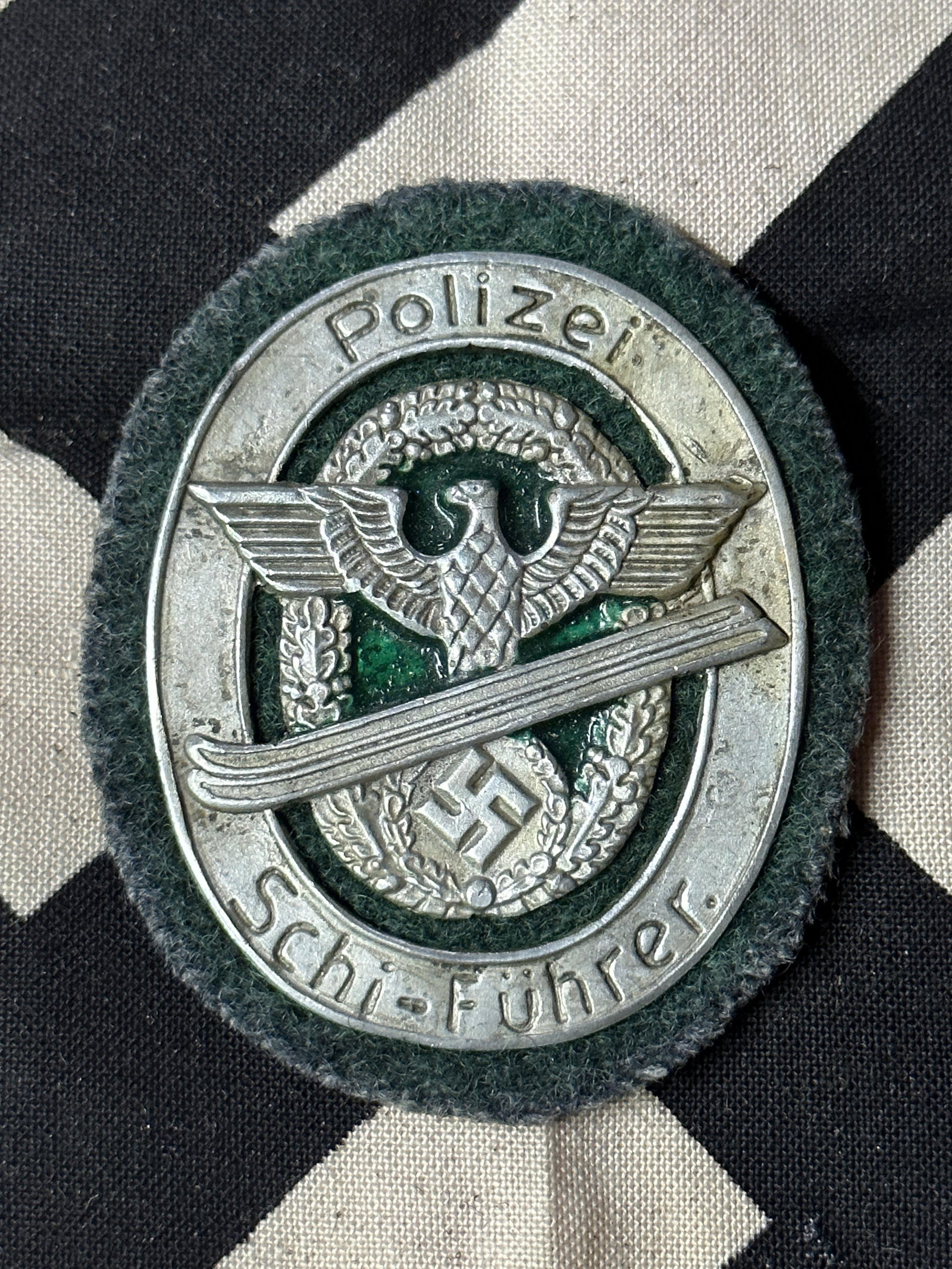 WW2 GERMAN POLICE EXPERT SKIER BADGE 1942 WITH GREEN BACKING MAKER MARKED MUNCHEN: WW2 GERMAN POLICE EXPERT SKIER BADGE 1942 WITH GREEN BACKING MAKER MARKED MUNCHEN. A RARE BADGE THAT IS IN MINT OVERALL SHAPE AND CONDITION WITH A BEAUTIFUL OVERALL PATINA. SHOWS GOOD WEAR AND USE. PL