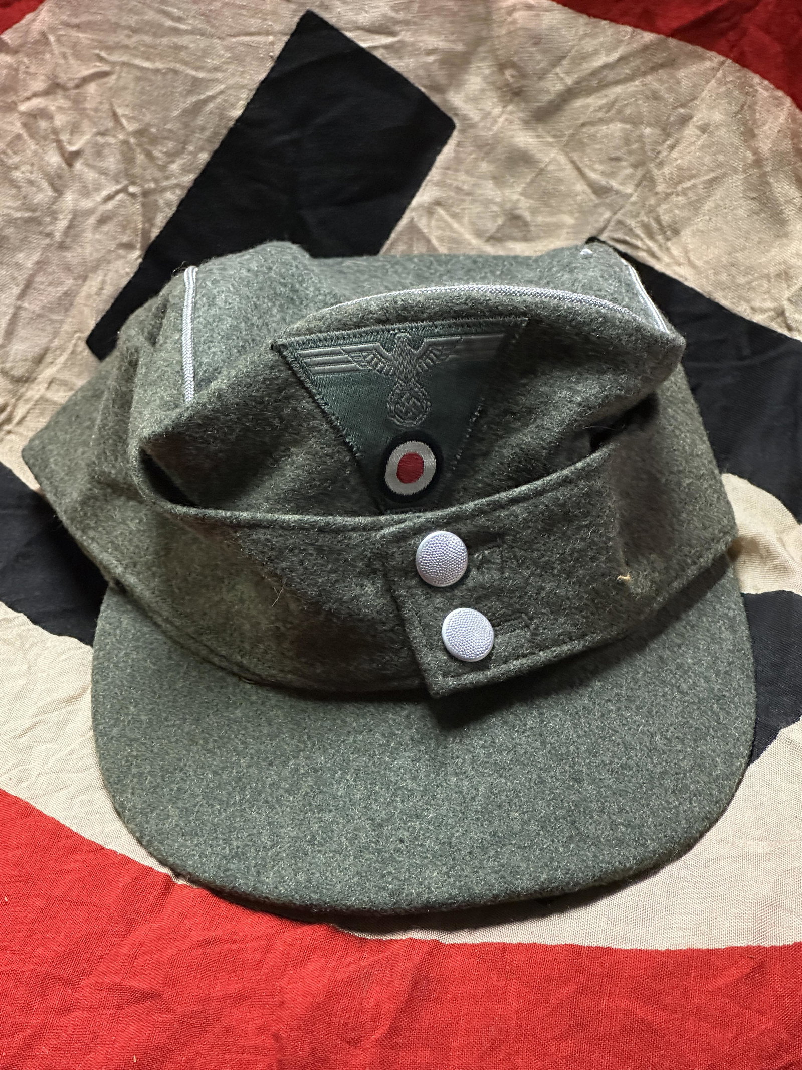 WW2 GERMAN WEHRMACHT M43 OFFICERS FIELD CAP: WW2 GERMAN WEHRMACHT M43 OFFICERS FIELD CAP. Wehrmacht M43 officers field cap dark green cloth with aluminum piping, sewn on trapezoid eagle, metal buttons by "A&S". Inside silk lining with leather sw