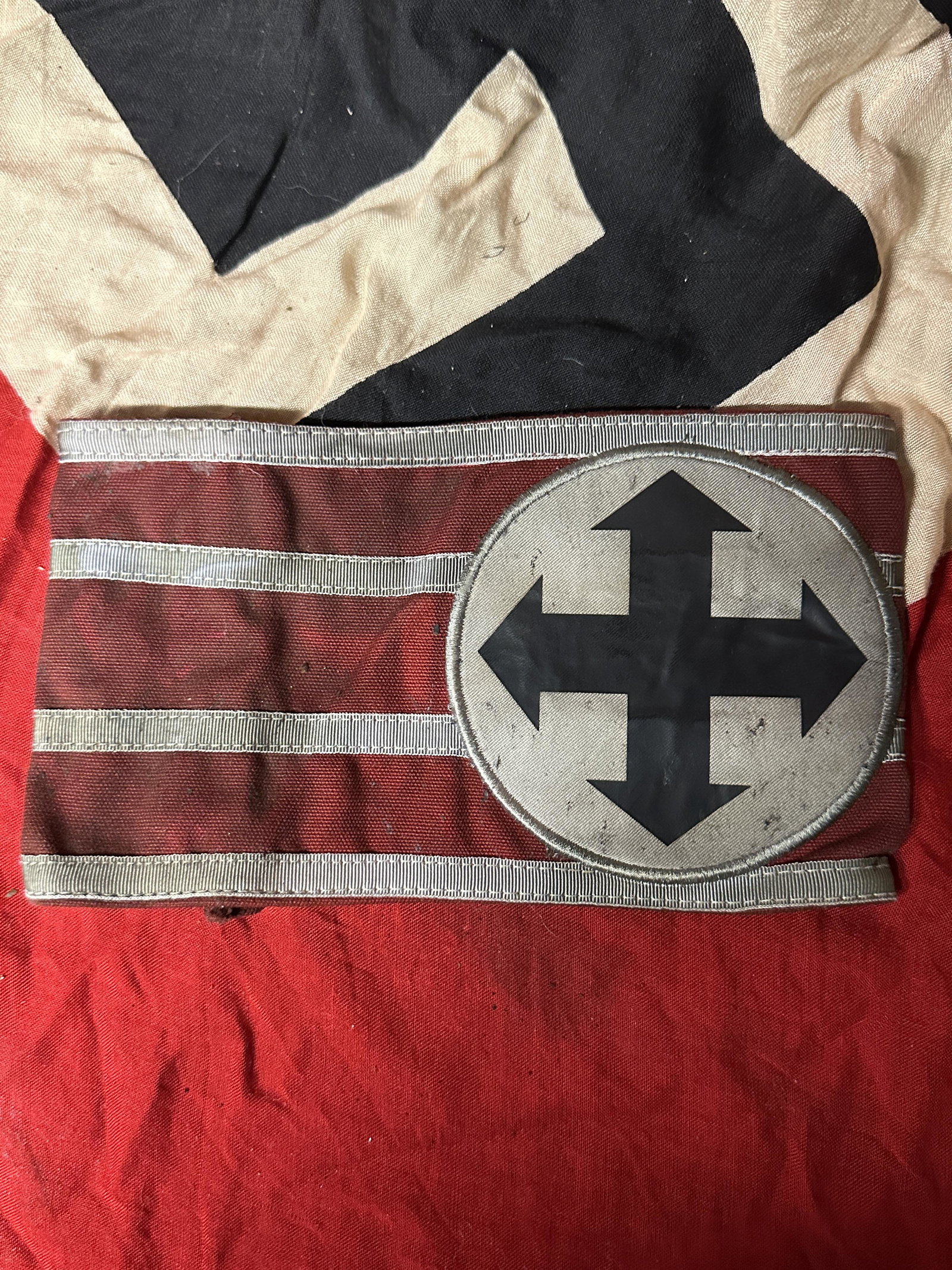WW2 GERMAN SS HUNGARIAN HIGH LEADER ARMBAND: WW2 GERMAN SS HUNGARIAN HIGH LEADER ARMBAND. THE FRONT SHOWS FOUR CROSSED ARROWS IN THE CENTER OF A ROUND CIRCLE. IT IS SEWN ONTO A RED RECTANGLE ARM BAND WITH FOUR WHITE HORIZONTAL STRIPES. MULTI PIE