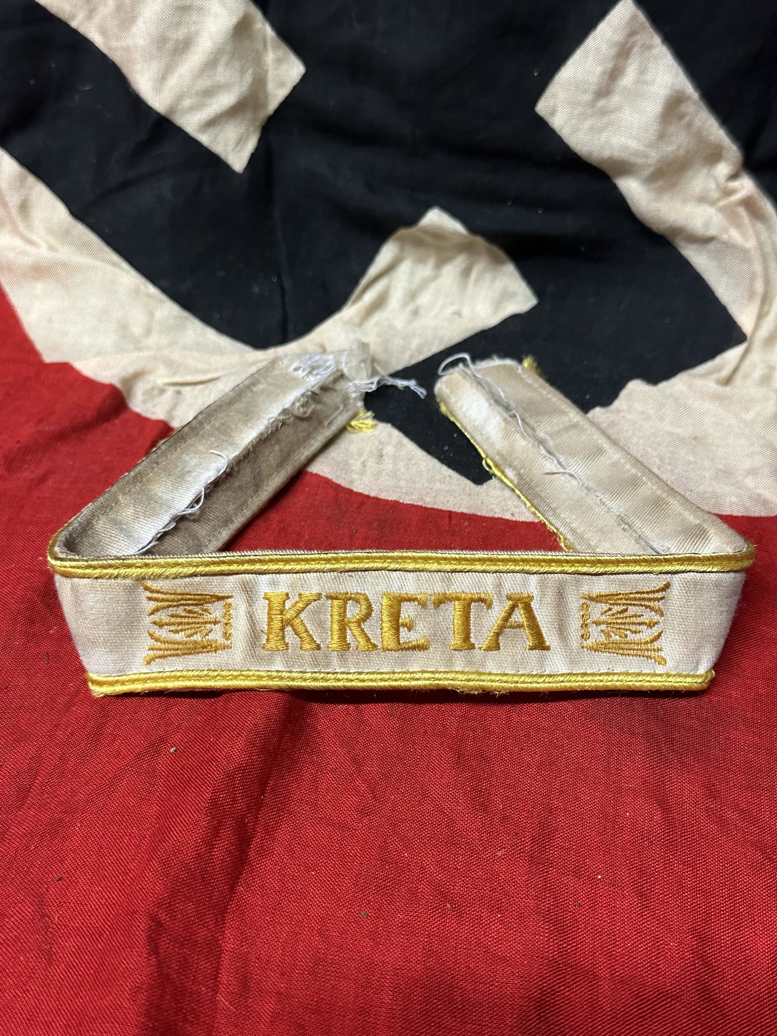 WW2 German WWII Kreta Campaign Cufftitle - Uniform Cut Off: WW2 German WWII Kreta Campaign Cufftitle - Uniform Cut Off. This is a nice but well worm and slightly damaged Kreta Campaign Cuff title which was removed from a uniform. It is white cotton constructio
