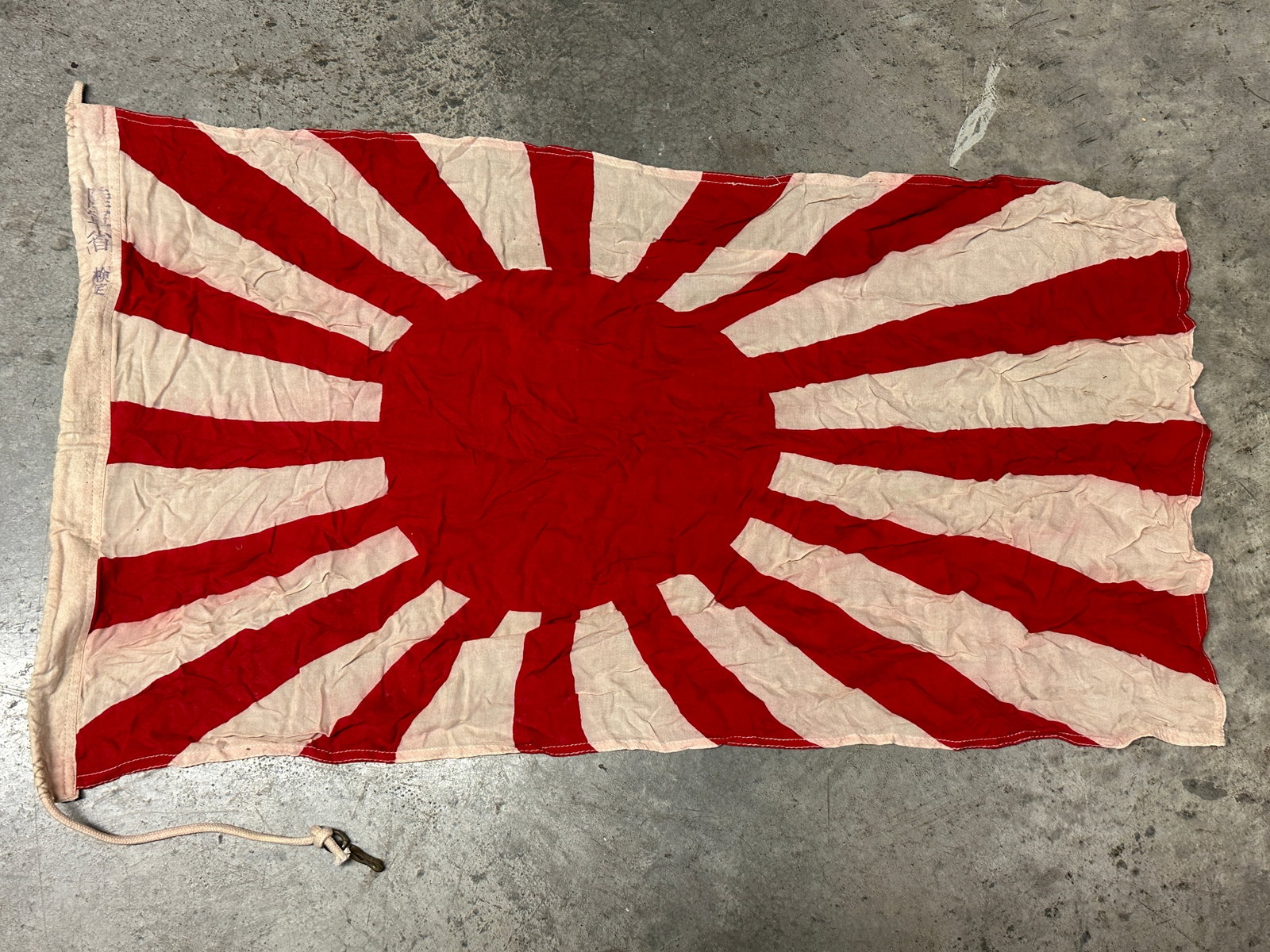 SIGNED WW2 IMPERIAL JAPANESE RISING SUN FLAG IN COTTON: SIGNED WW2 IMPERIAL JAPANESE RISING SUN FLAG IN COTTON. SIGNED ON THE SIDES. SHOWS GOOD WEAR AND USE WITH A BEAUTIFUL PATINA THROUGHOUT. LOOKS ABSOLUTELY STUNNING. PLEASE VIEW ALL DETAILED PICTURES. A