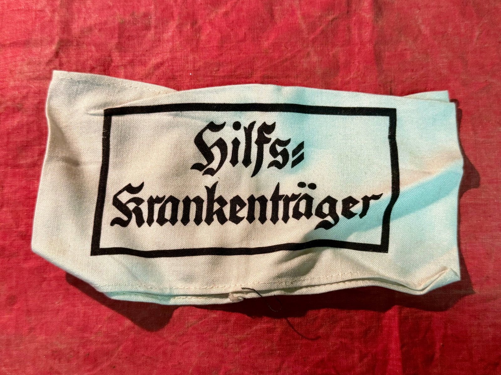 WW2 German Wehrmacht Hilfs-Krankenträger Stretcher Bearer Armband: WW2 German Wehrmacht Hilfs-Krankenträger Stretcher Bearer Armband. (Auxiliary Stretcher Bearer) early version embroidered in black thread on white cotton, within a black border, measuring 381mm (w) x