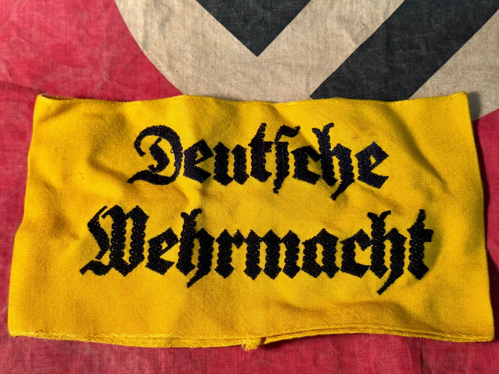 German WWII "Deutsche Wehrmacht" German Embroidered Yellow Armband: German WWII "Deutsche Wehrmacht" German Embroidered Yellow Armband. The armband is made of a yellow cotton blend with black embroidered text that reads Deutsche Wehrmacht (German Armed Forces). Shows 