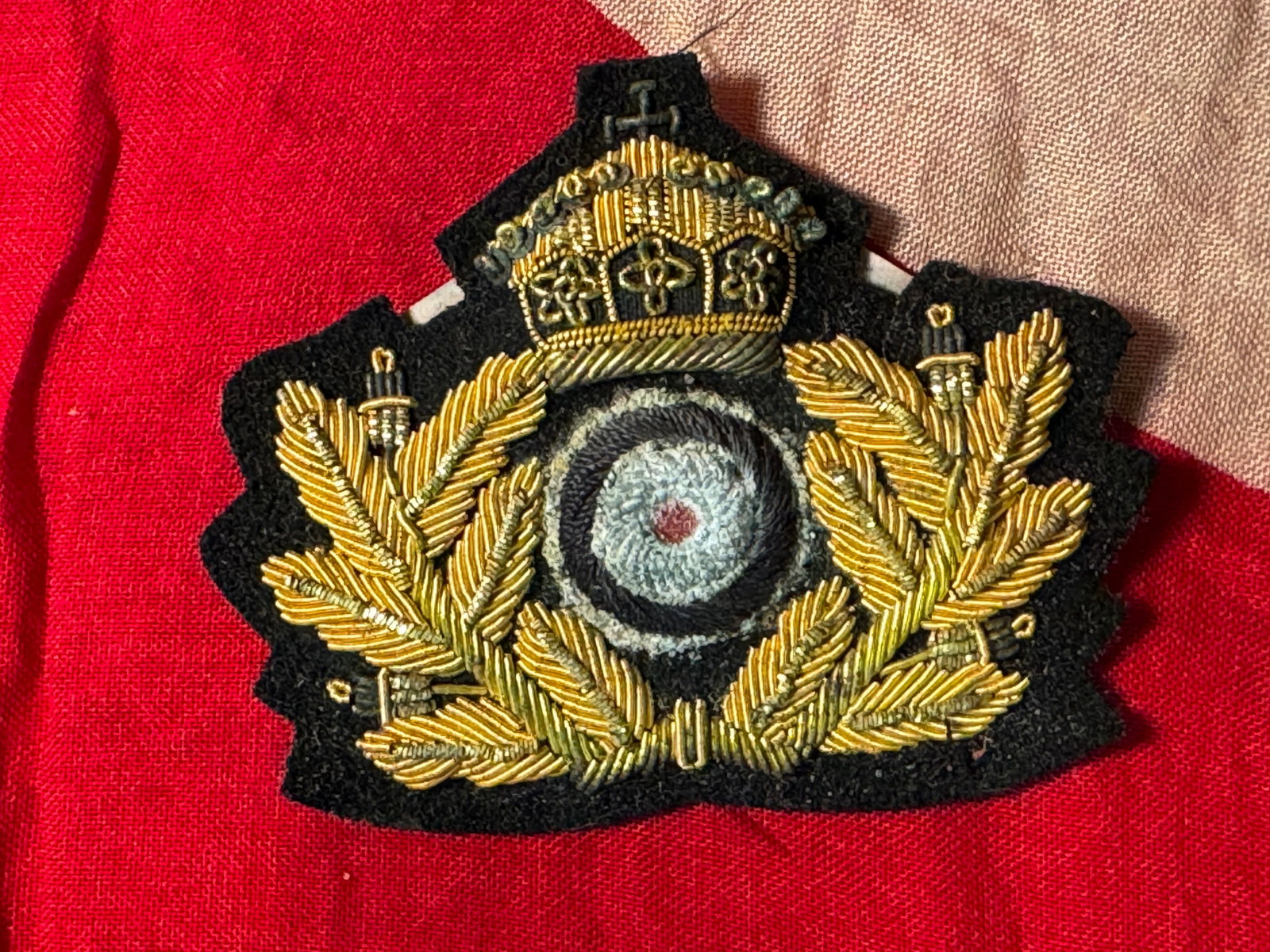 WW1 IMPERIAL GERMAN NAVAL (KAISERLICHE MARINE) RESERVE OFFICERS CAP COCKADE: WW1 IMPERIAL GERMAN NAVAL (KAISERLICHE MARINE) RESERVE OFFICERS CAP COCKADE. Being a fine bullion embroidered crowned wreath with bullion embroidered roundel. Shows good wear and use with a beautiful 