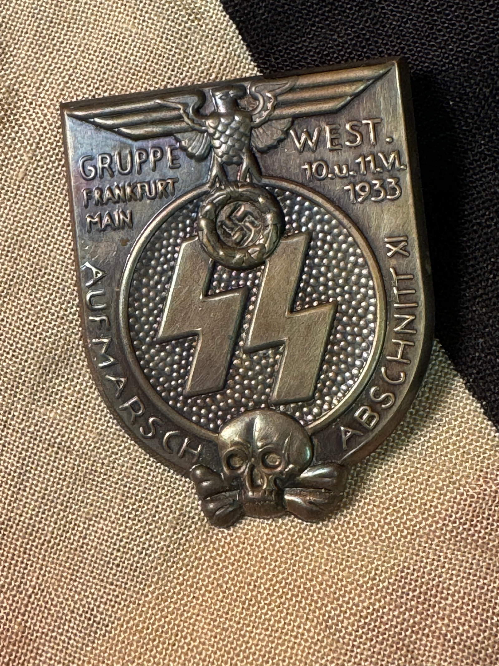 WW2 German SS Gruppe West Frankfurt 1933 Tinnie: WW2 German SS Gruppe West Frankfurt 1933 Tinnie. This SS day badge was for a deployment/marching event taking place in Frankfurt/Main under SS Group West, Abschnitt XI. Shows good wear and use with a 