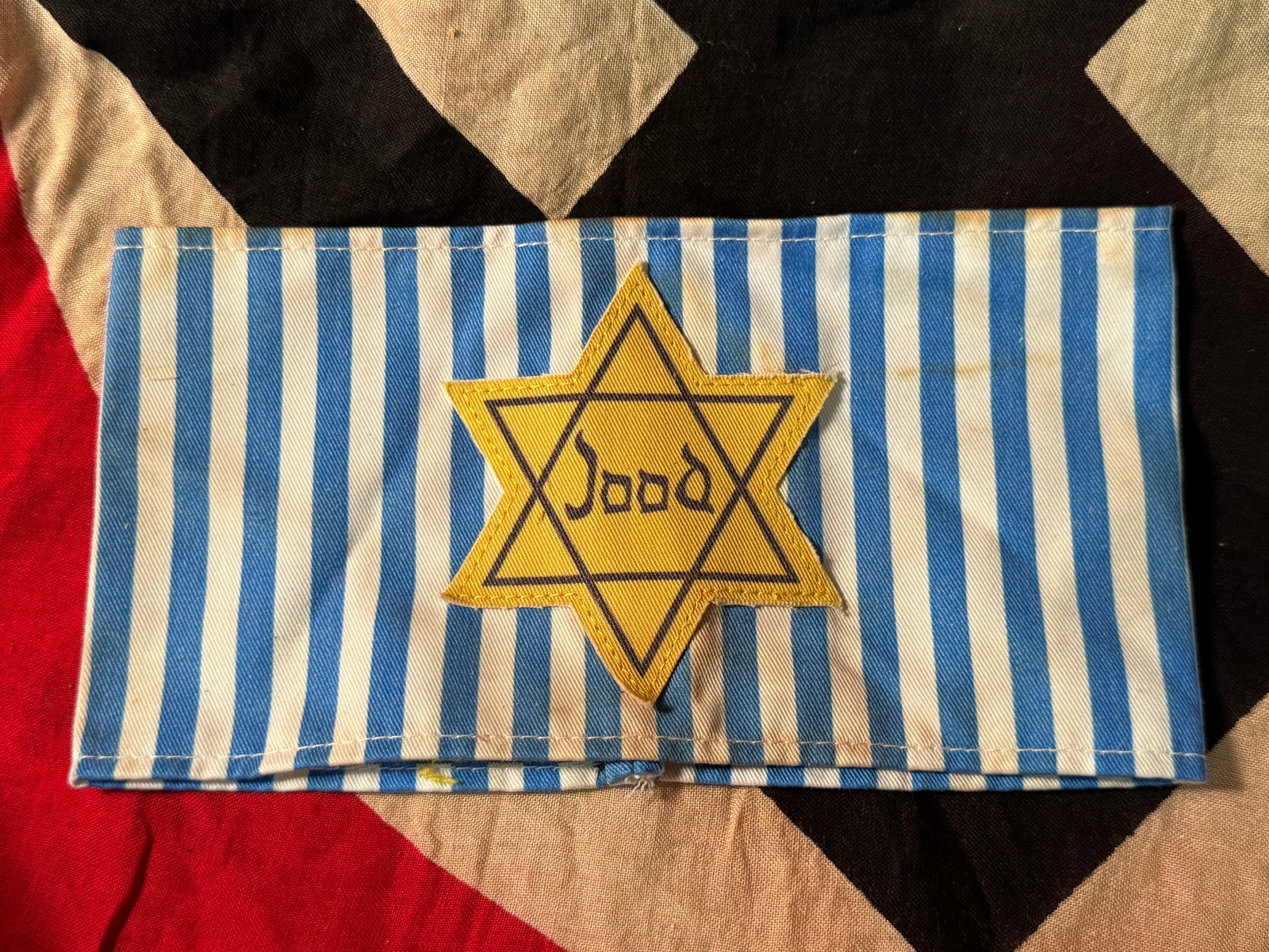 SCARCE WW2 GERMAN NETHERLANDS JOOD STAR ARMBAND: SCARCE WW2 GERMAN NETHERLANDS JOOD STAR ARMBAND. SHOWS GOOD WEAR AND USE WITH A BEAUTIFUL OVERALL PATINA. HAS THE JOOD STAR OF DAVID SEWN ON THE FRONT. PLEASE VIEW ALL DETAILED PICTURES. A VERY RARE F