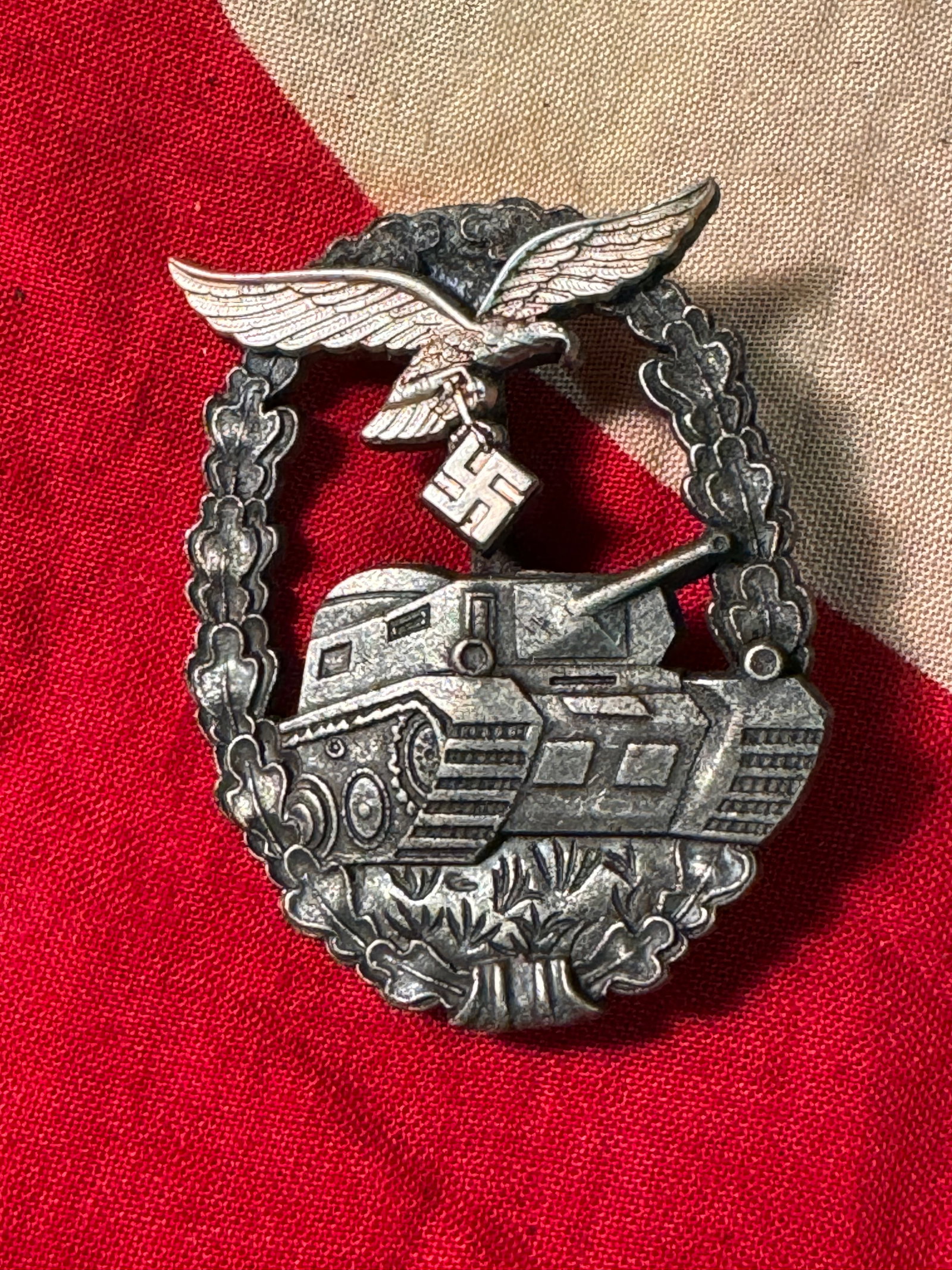 WWII German Luftwaffe Panzer Assault Badge: WWII German Luftwaffe Panzer Assault Badge. Die-struck in nickel silver, German WWII Luftwaffe Panzer Assault Badge is two-piece badge featuring an antique silver, or alt-silber, plated tank and wreat
