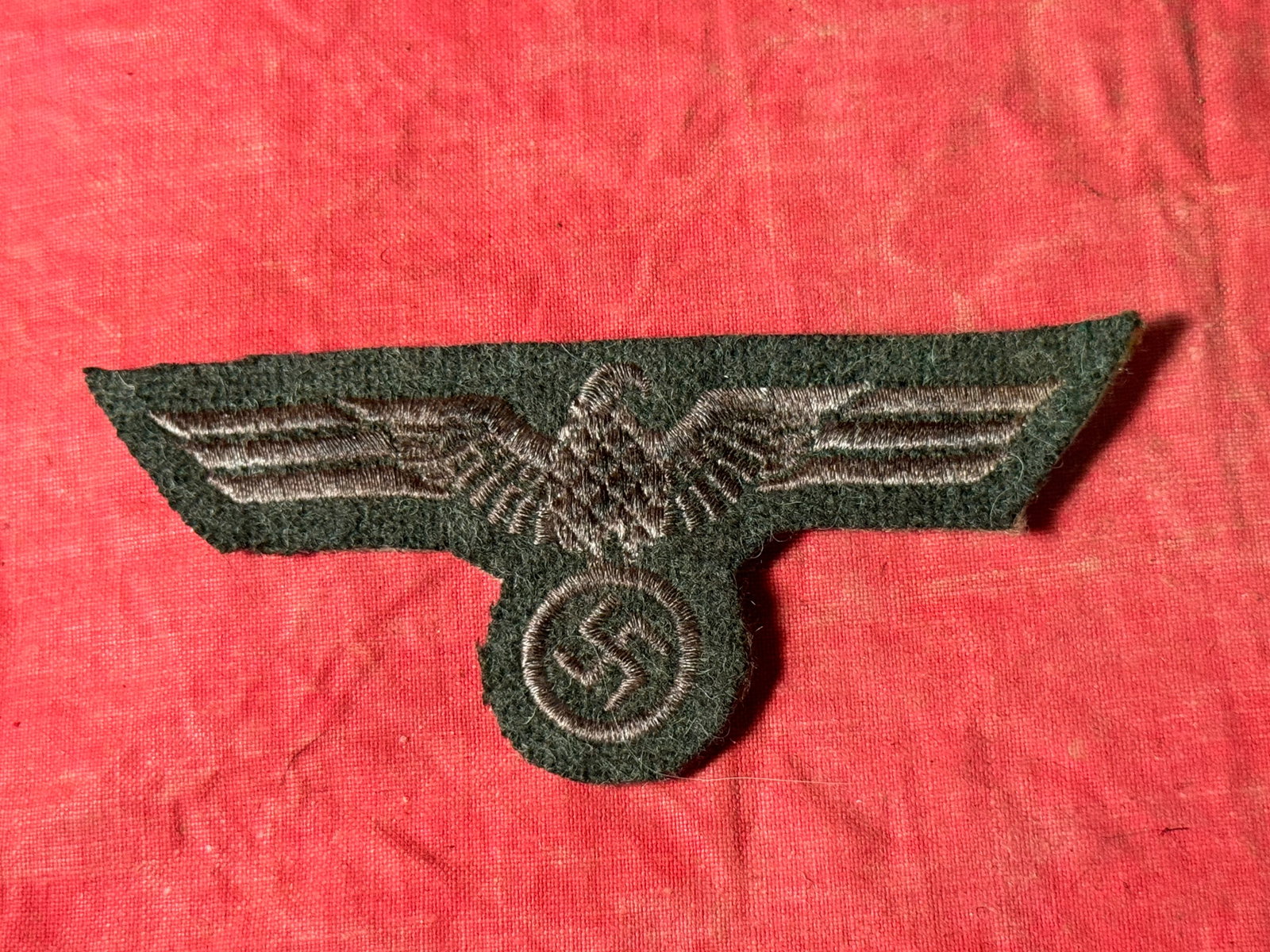 German WWII Heer Enlisted Waffenrock Eagle: German WWII Heer Enlisted Waffenrock Eagle. Silver flat wire embroidery on feldgrau wool backing material. A well made antique German artifact.