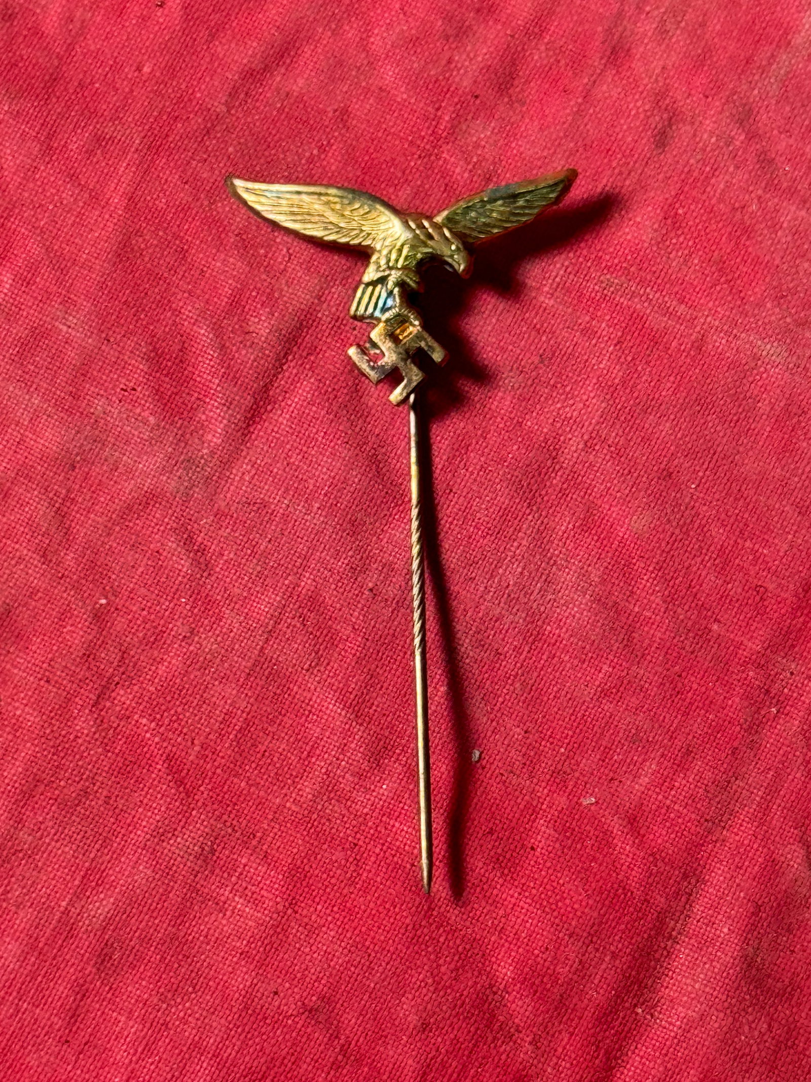 WW2 GERMAN BRONZE PIN REPRESENTING THE PARTEIADLER OF NAZI GERMANY: WW2 GERMAN BRONZE PIN REPRESENTING THE PARTEIADLER OF NAZI GERMANY. The pin has an eagle with long outstretched wings, holding a swastika and looking to its left. Narrative: The German eagle is a symb