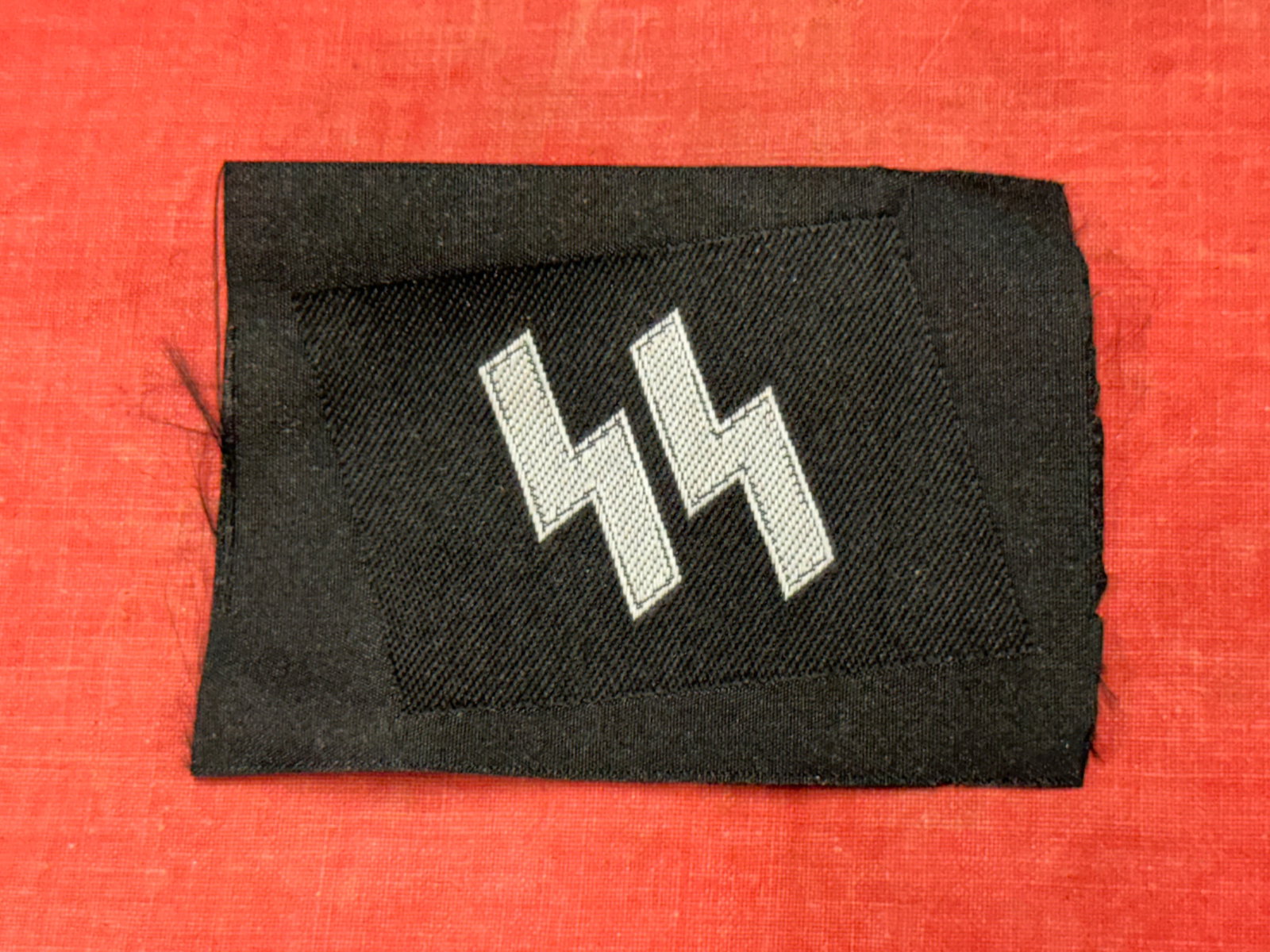 RARE WW2 GERMAN WAFFEN-SS RUNIC COLLAR TAB IN CLOTH: RARE WW2 GERMAN WAFFEN-SS RUNIC COLLAR TAB IN CLOTH. A RARE FIND. SHOWS GOOD WEAR AND USE WITH A BEAUTIFUL OVERALL PATINA. PLEASE VIEW ALL DETAILED PICTURES. A SCARCE EXAMPLE.