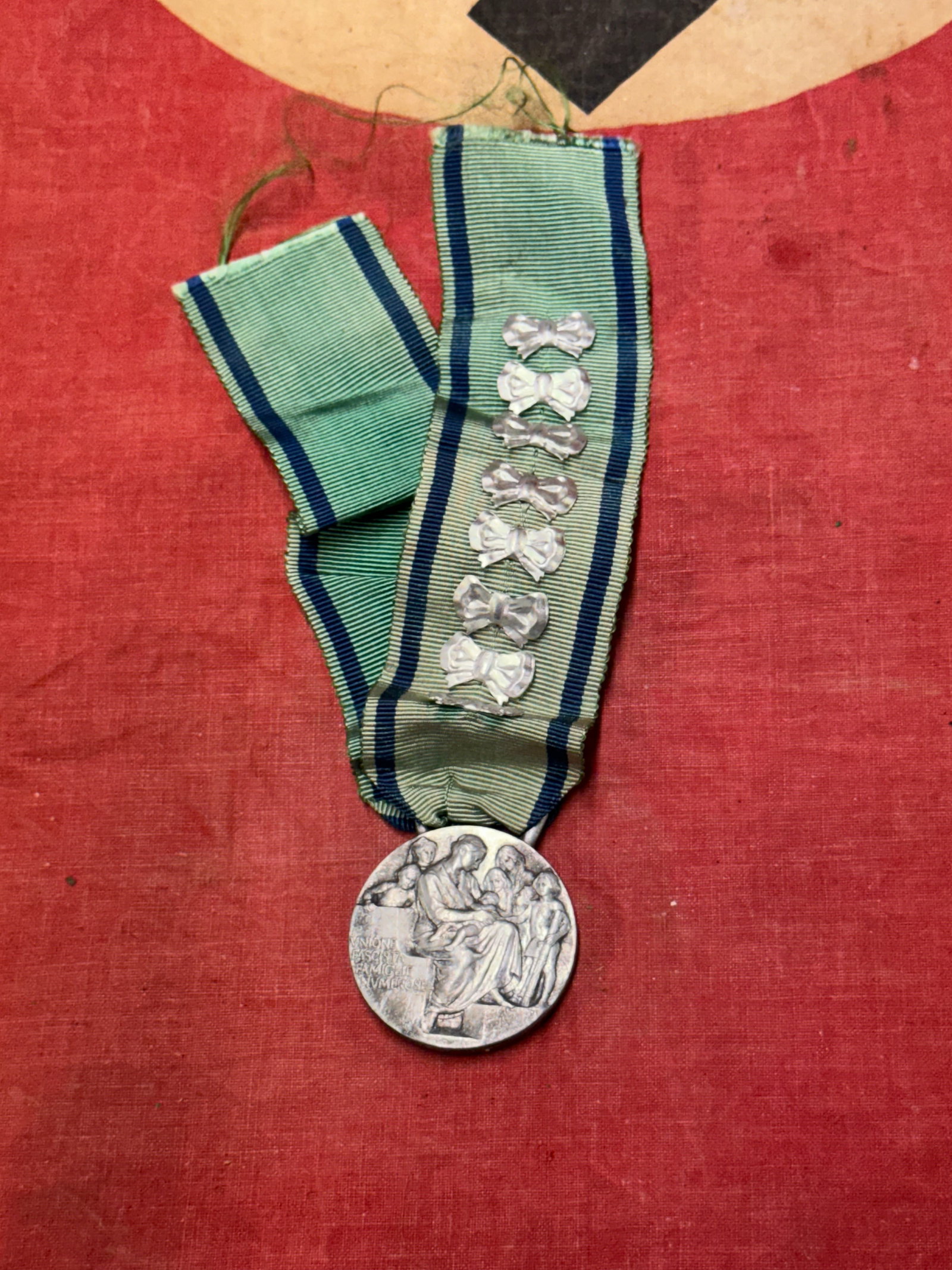 Italy WWII Mother's Medal of the Fascist Union of Large Families with Bows: Italy WWII Mother's Medal of the Fascist Union of Large Families with Bows. A rare example that was brought back home by a vet. The Union was established in 1937 and its goal was the support of famili