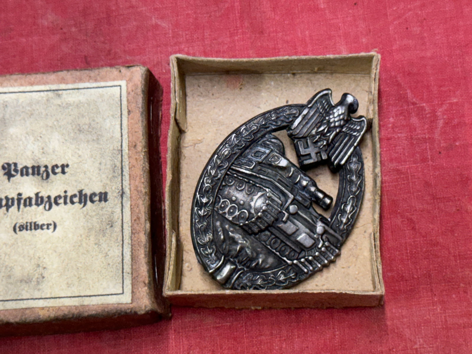 WW2 GERMAN PANZER ASSAULT TANK BADGE IN SILVER WITH ORIGINAL BOX: WW2 GERMAN PANZER ASSAULT TANK BADGE IN SILVER WITH ORIGINAL BOX. A VERY SCARCE EXAMPLE. SHOWS GOOD WEAR AND USE WITH A BEAUTIFUL OVERALL PATINA. PLEASE VIEW ALL DETAILED PICTURES. A VERY SCARCE EXAMP