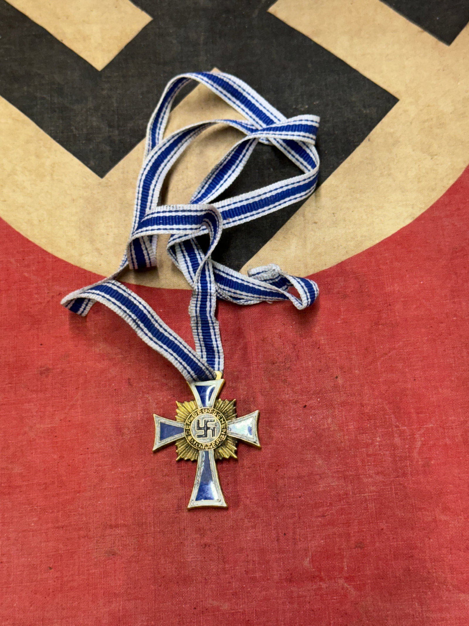 RARE WW2 GERMAN MOTHER'S CROSS IN GOLD WITH RIBBON: RARE WW2 GERMAN MOTHER'S CROSS IN GOLD WITH RIBBON. A VERY RARE EXAMPLE. SHOWS GOOD USE AND WEAR AND A BEAUTIFUL PATINA THROUGHOUT. PLEASE VIEW ALL DETAILED PICTURES. A RARE EXAMPLE.